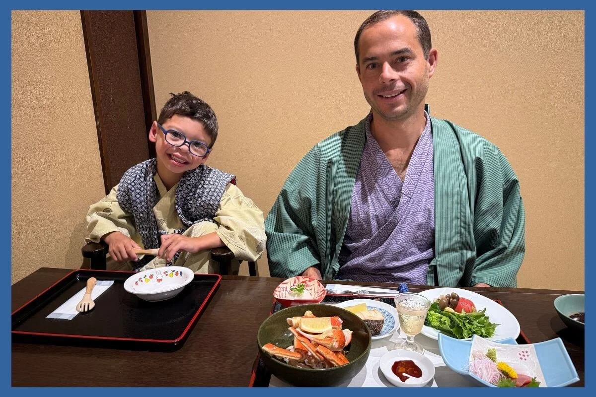 Child and father enjoying a traditional kaiseki dinner at their ryokan in Hakone, Japan.