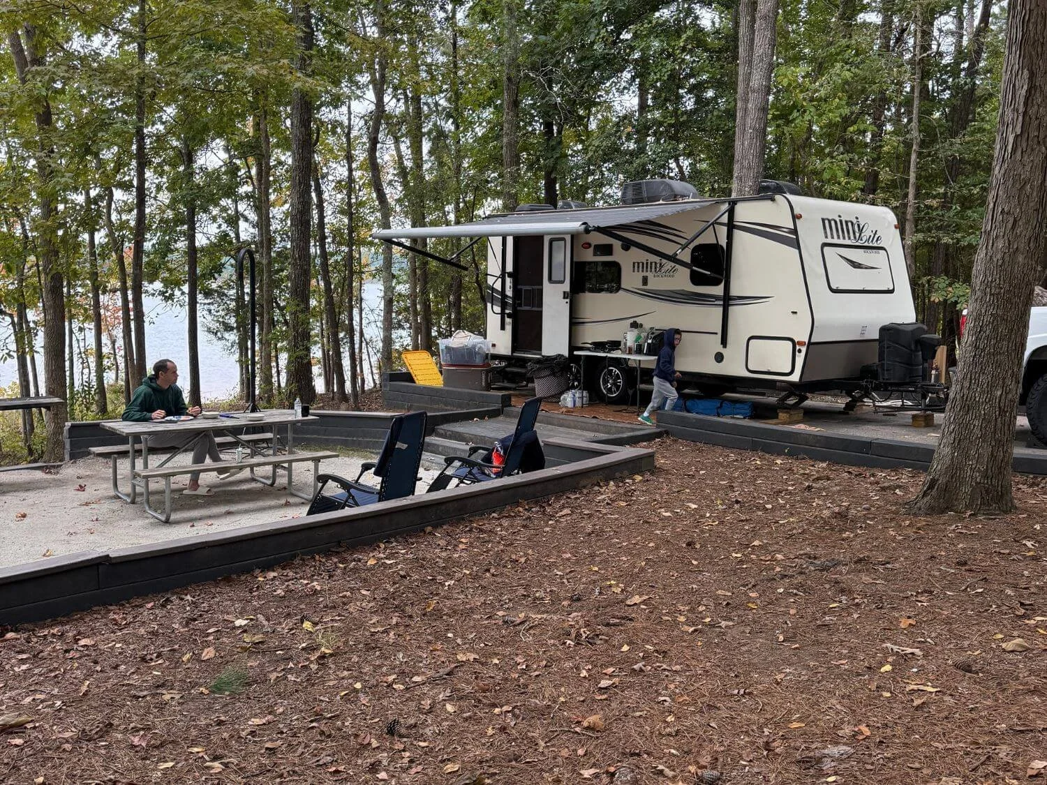 Wide shot of the campsite with the camper and the lake behind it at Calhoun Falls State Park in South Carolina.