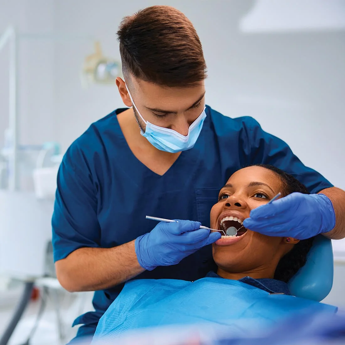 Dentist examining a patient’s teeth during a dental appointment.