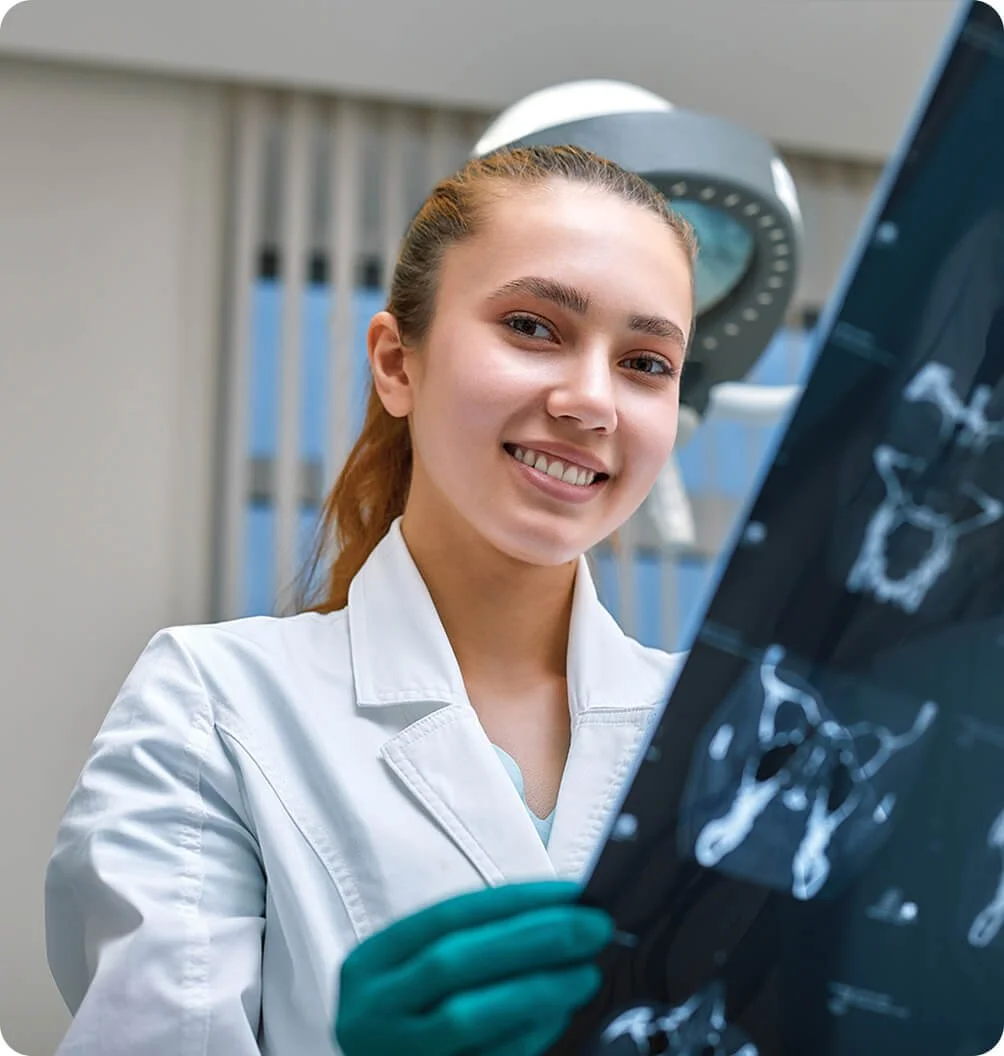 Healthcare professional in a lab coat reviewing a medical imaging scan.