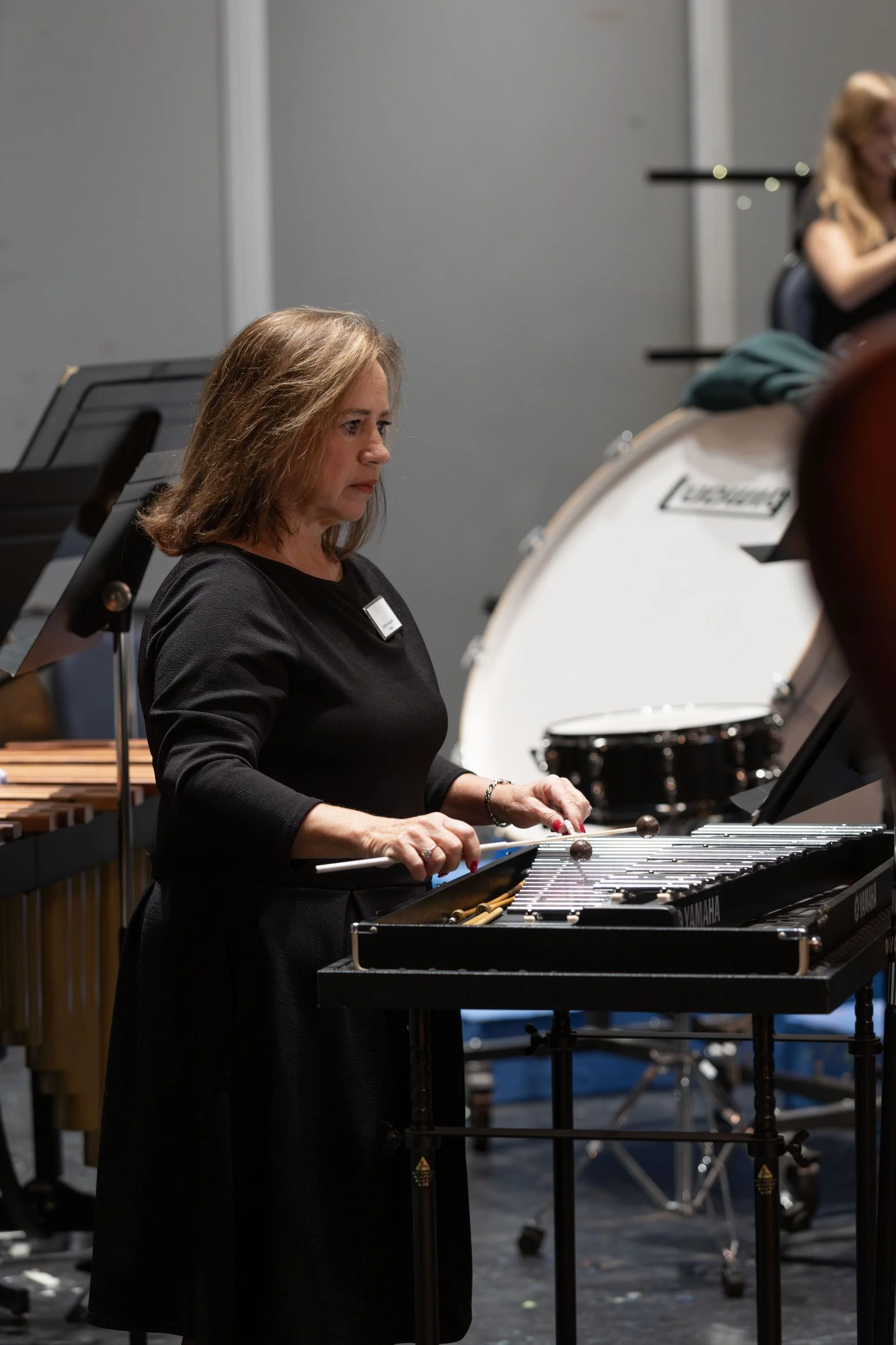 A woman playing a vibraphone in a performance setting.