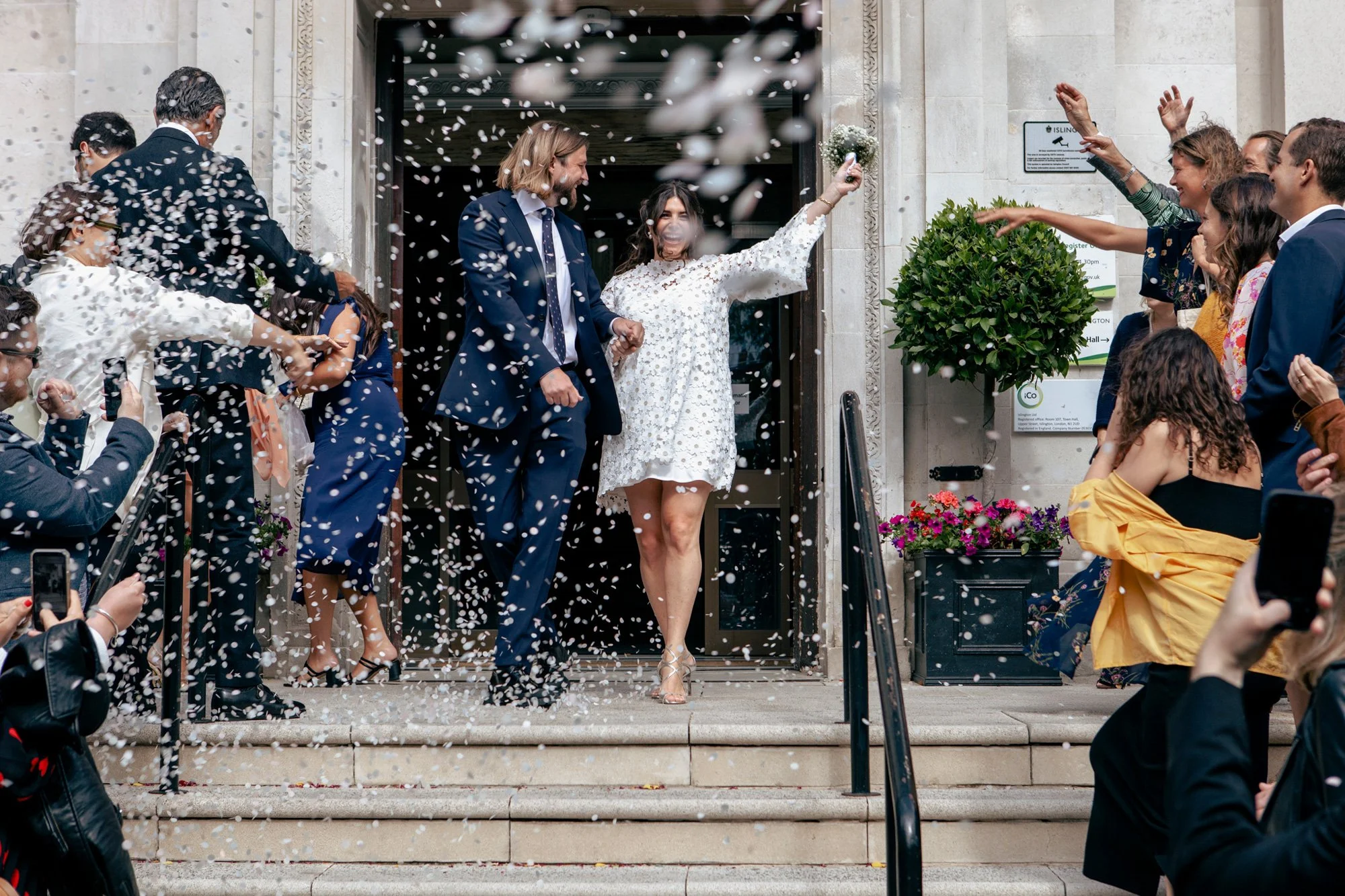 Guests-throwing-confetti-at-couple-leaving-town-hall.jpg