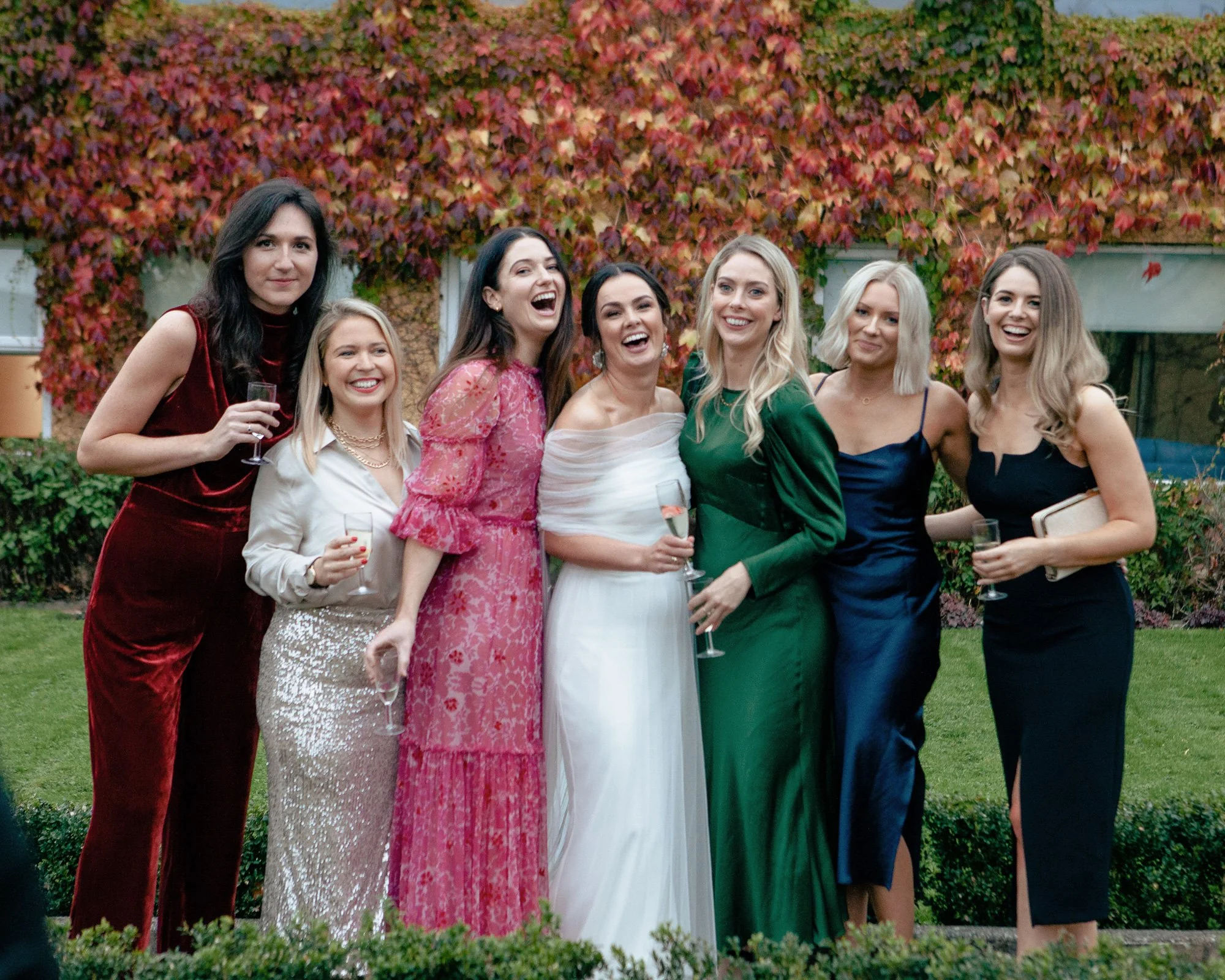 Bride-and-bridesmaid-posing-in-wedding-venue-garden.jpg