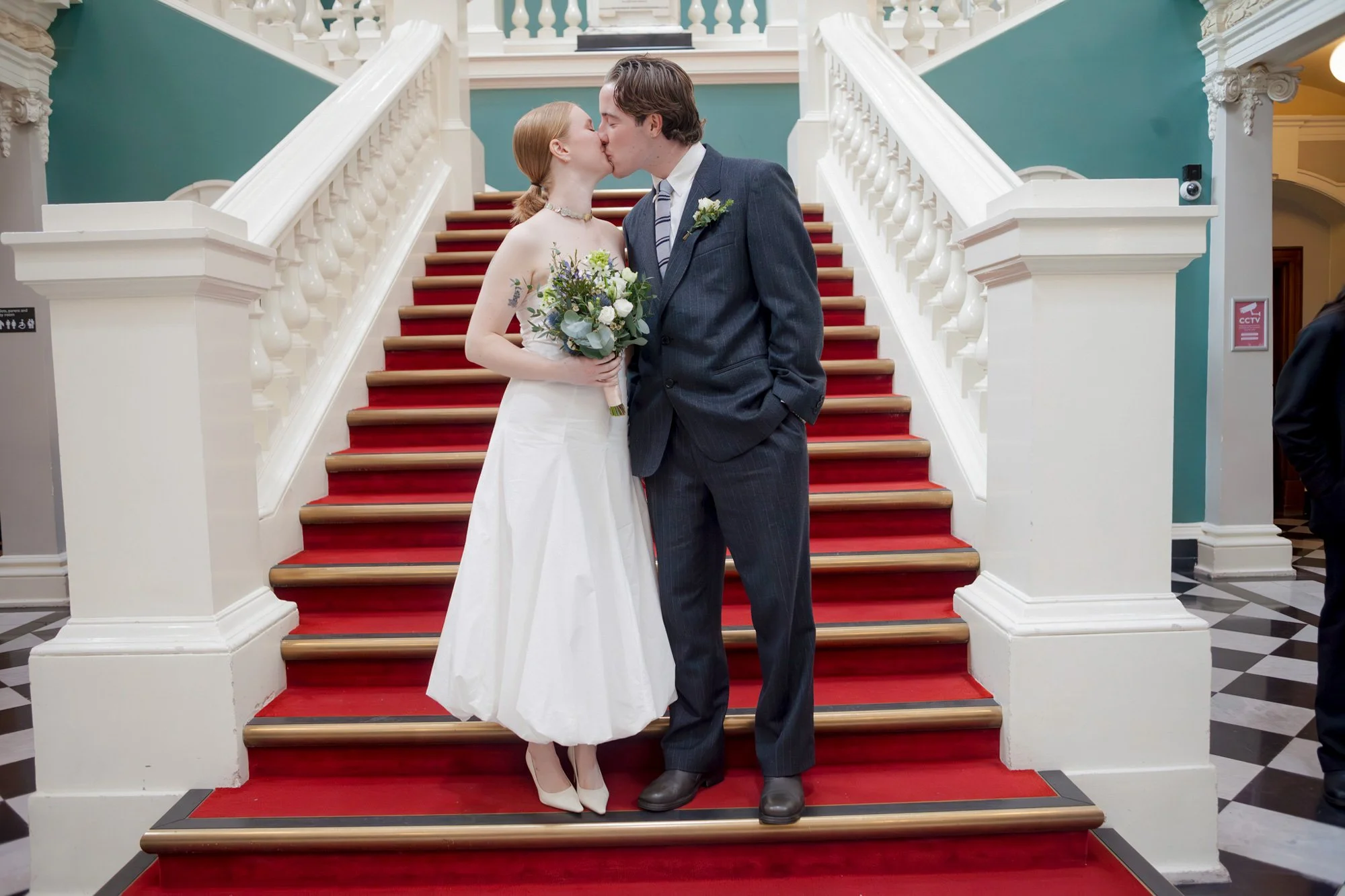 Married-couple-at-Woolwich-town-hall-kiss-on-interior-steps.jpg