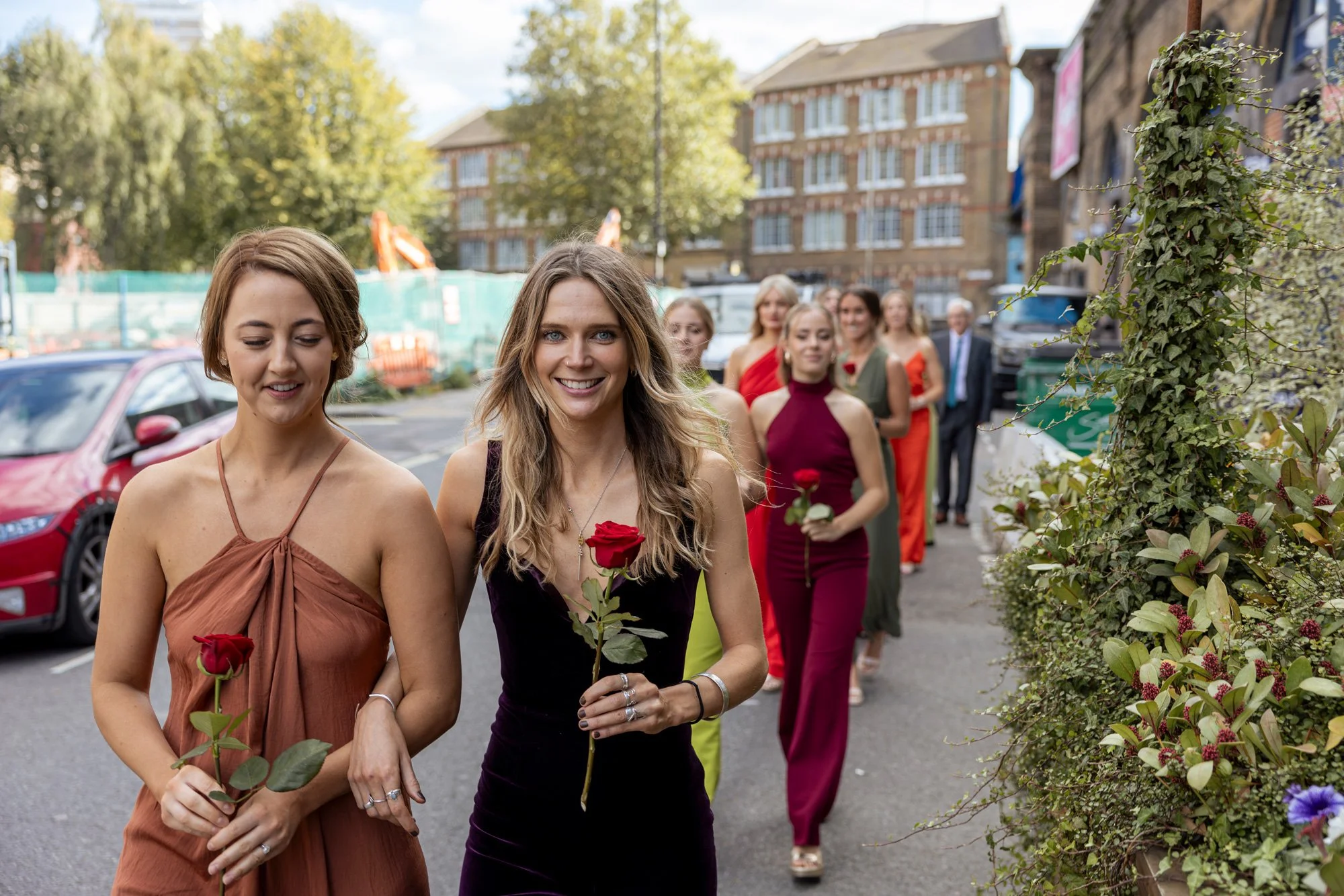 Bridesmaids-walk-into-venue-holding-flowers.jpg