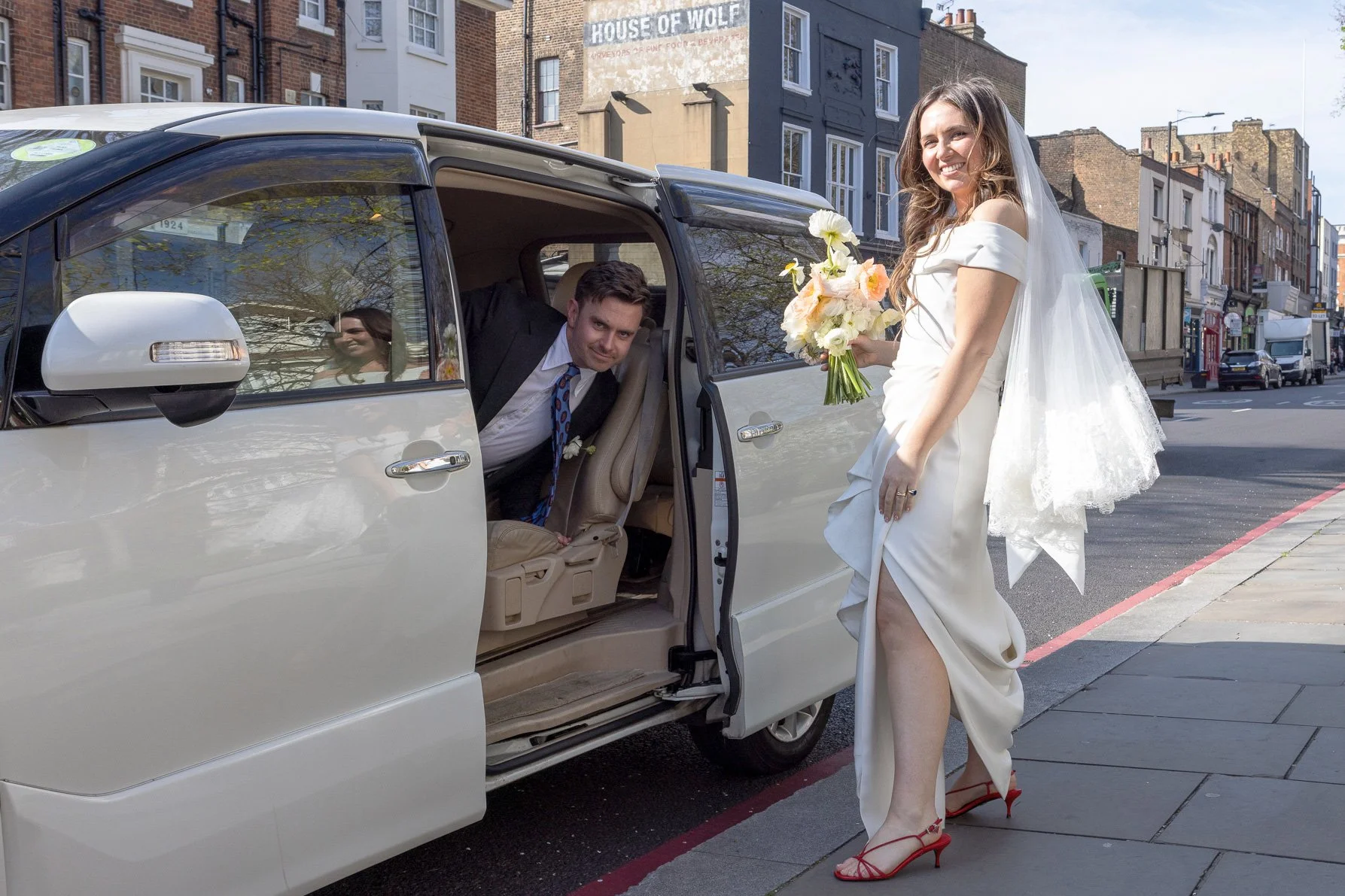 Fun-wedding-couple-getting-in-to-car-posing.jpg