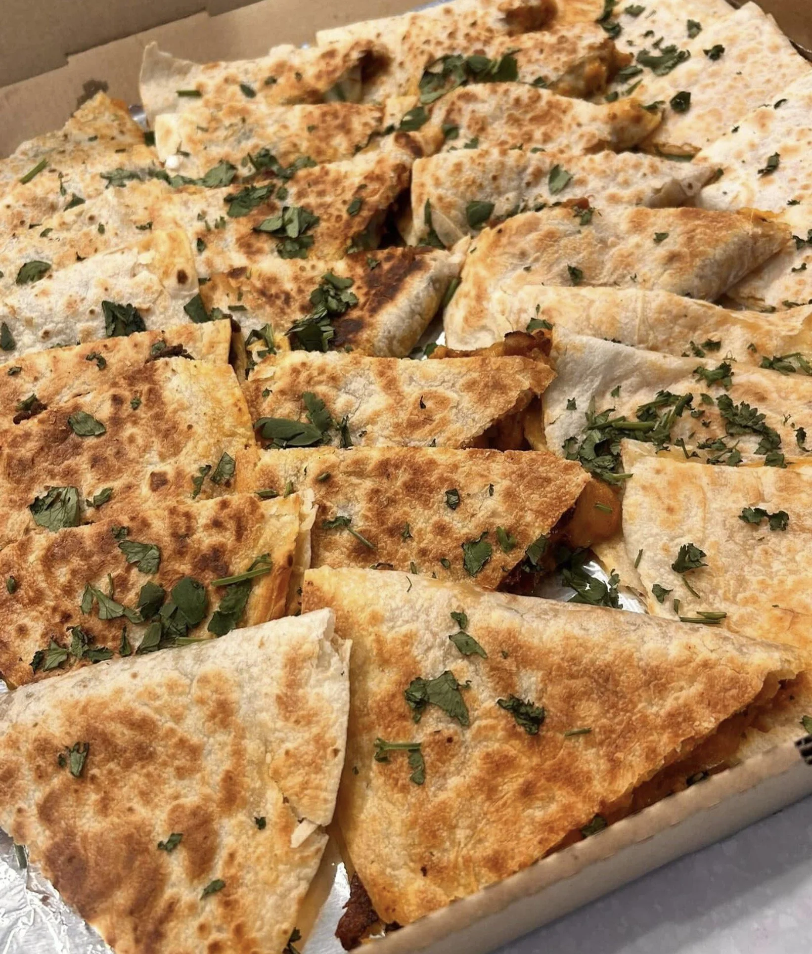 Close-up view of sliced quesadillas garnished with chopped cilantro.