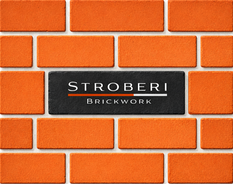 Close-up of a brick wall with a black sign that reads "Stroberi Brickwork" in white letters.