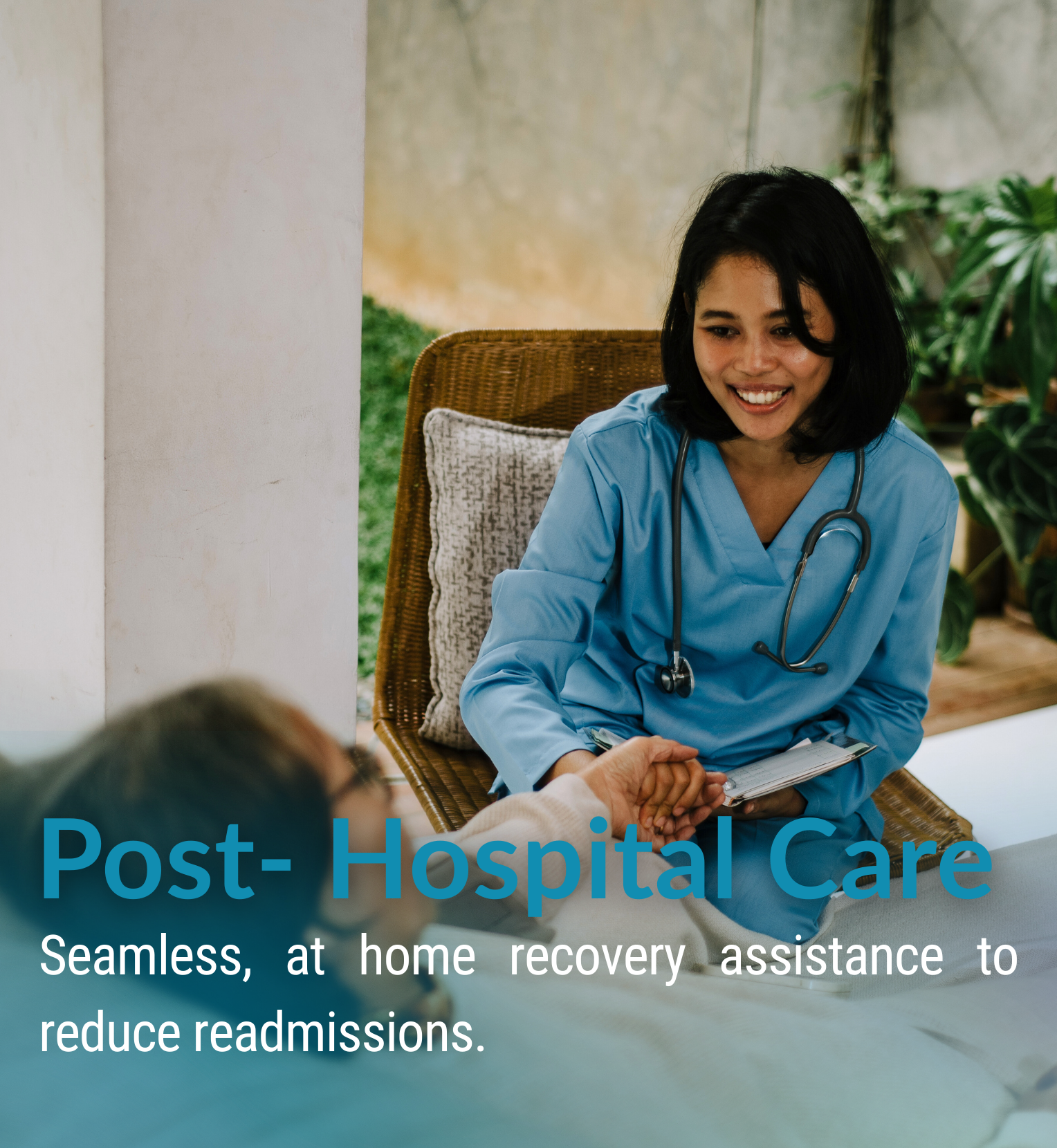 A nurse or healthcare professional in blue scrubs sitting in a wicker chair, holding hands and smiling at a patient in a hospital bed, with greenery and plants in the background.