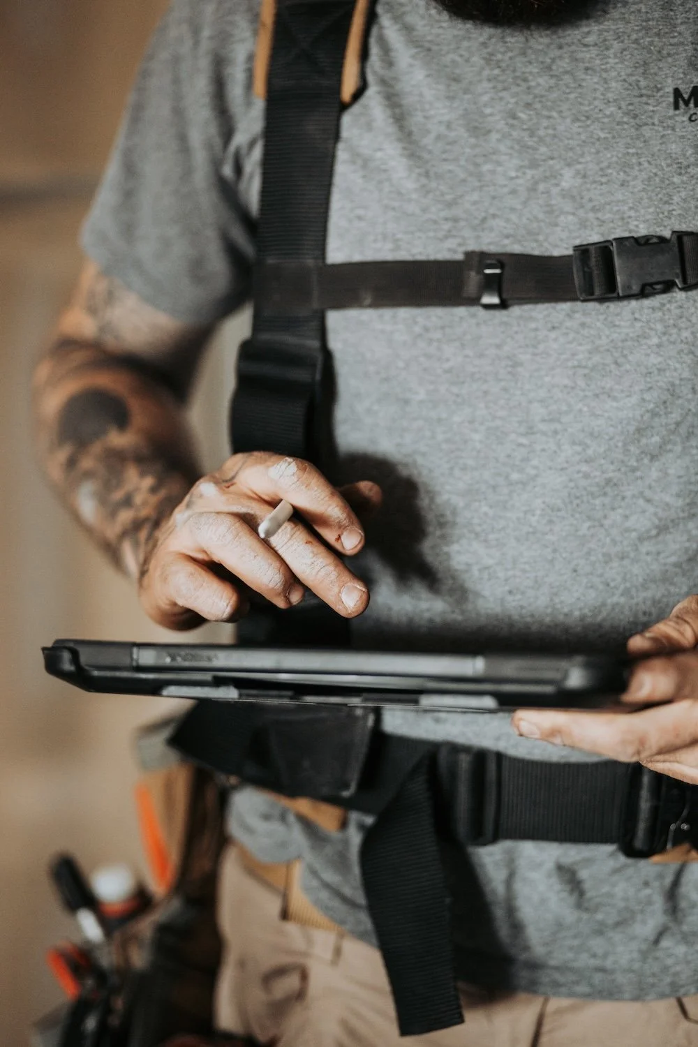 HVAC technician using tablet during on-site mechanical service.
