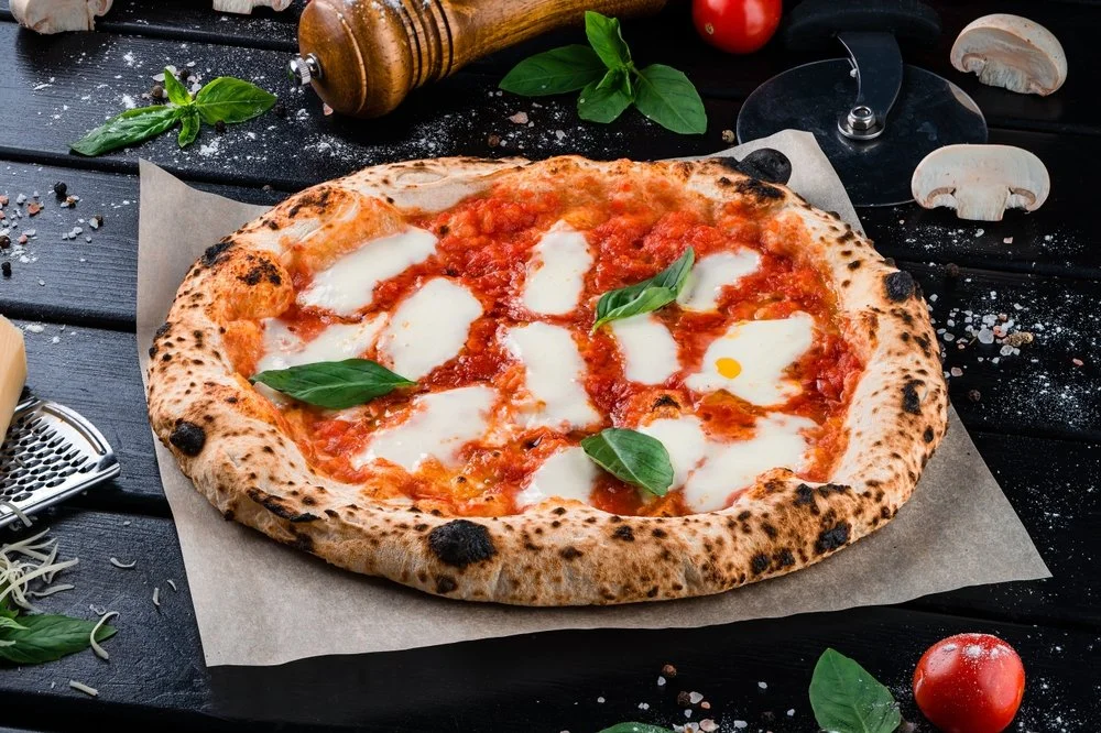 A delicious margarita pizza with mozzarella, basil leaves, and tomato sauce.  Tasty and professional
