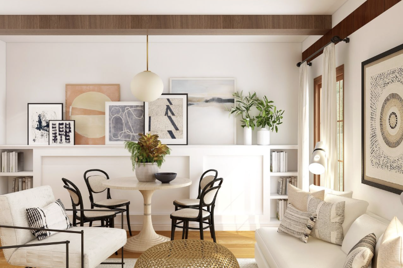 Living room with a round dining table, four black chairs, a white sofa with decorative pillows, wall art, a hanging pendant light, and built-in bookshelves with books and plants.