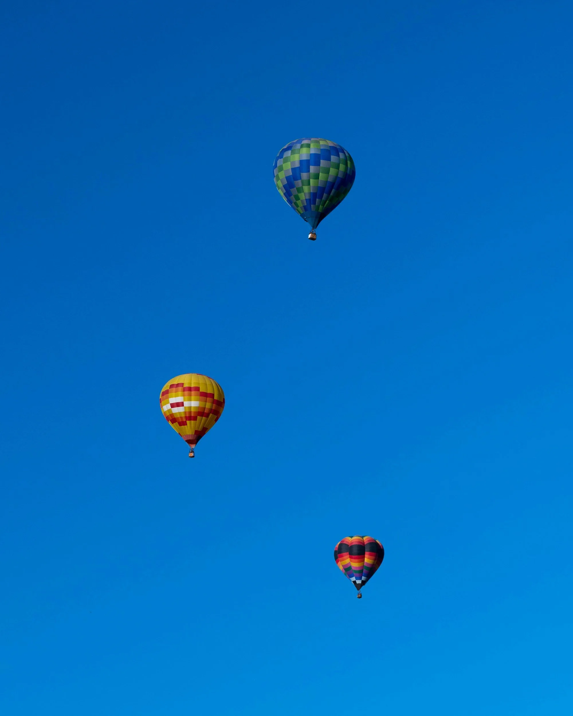 3 hot air balloons in blue sky