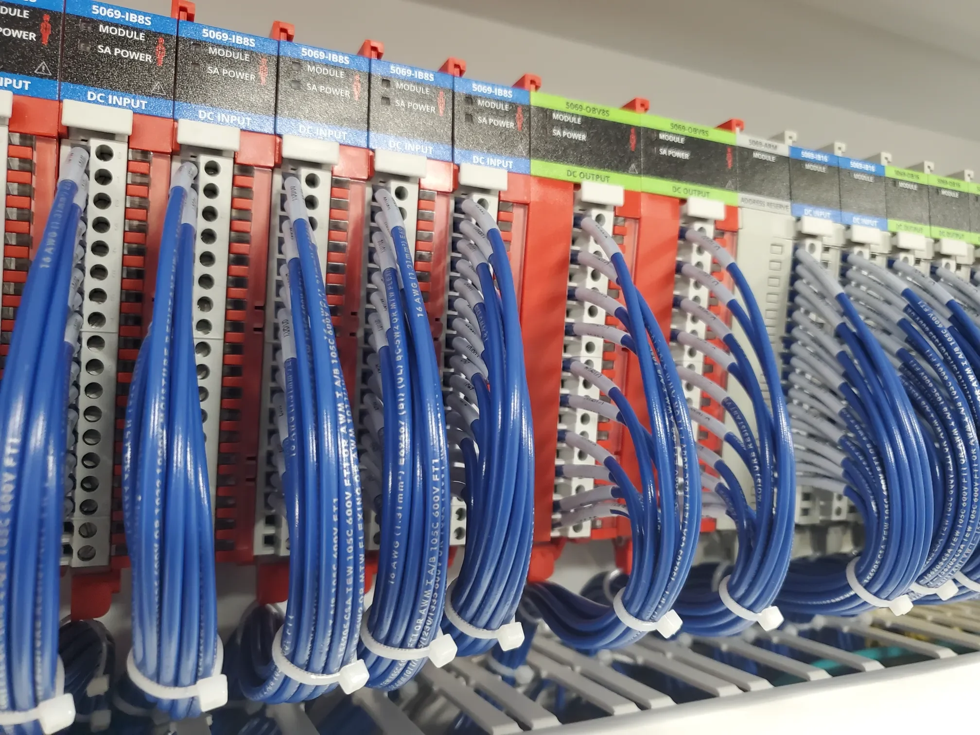 Electrical control panel with blue wires connected to terminal blocks labeled 'DC INPUT' and 'DC OUTPUT'