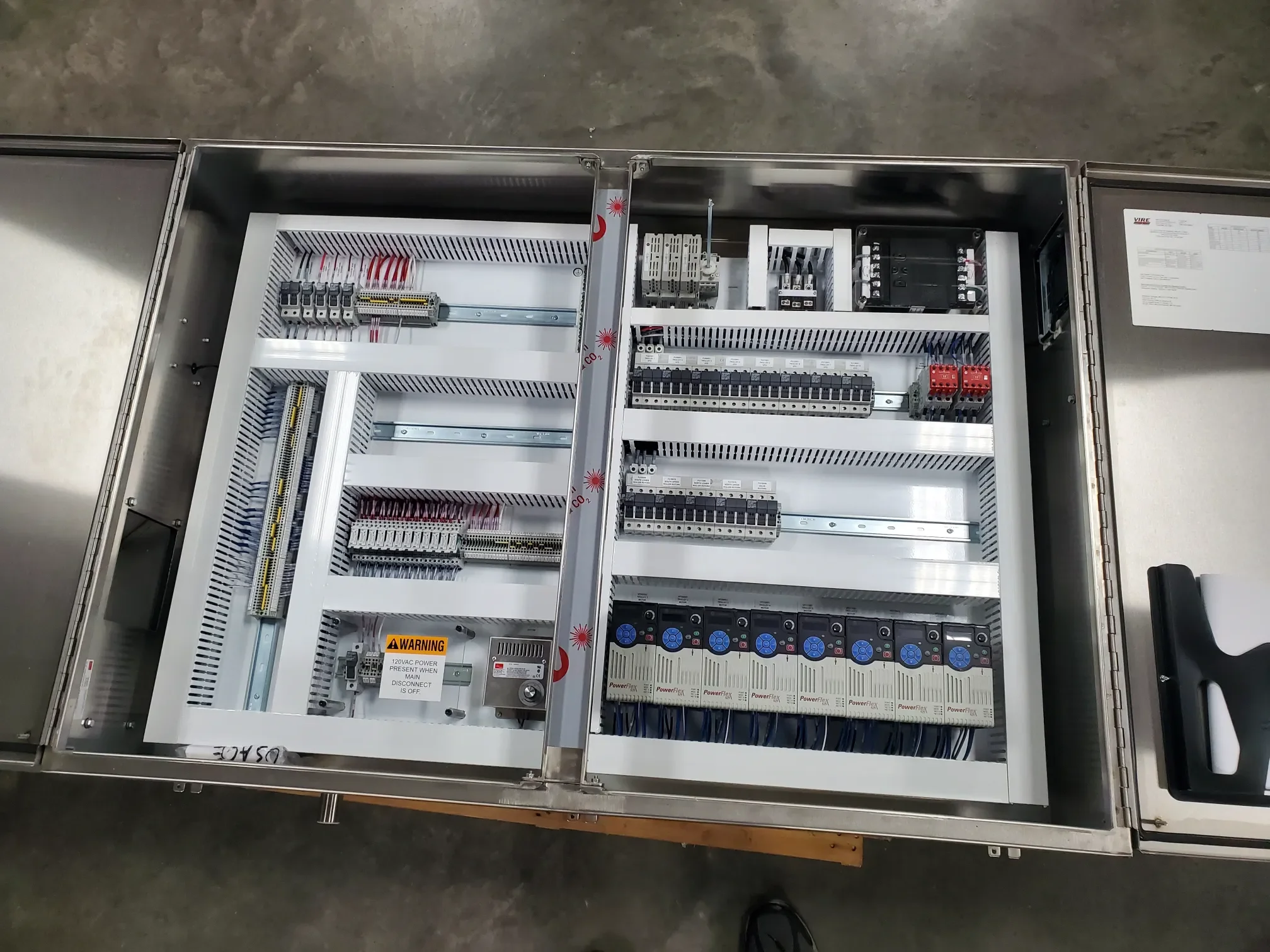 Open electrical control panel with various circuit breakers, relays, and wiring.