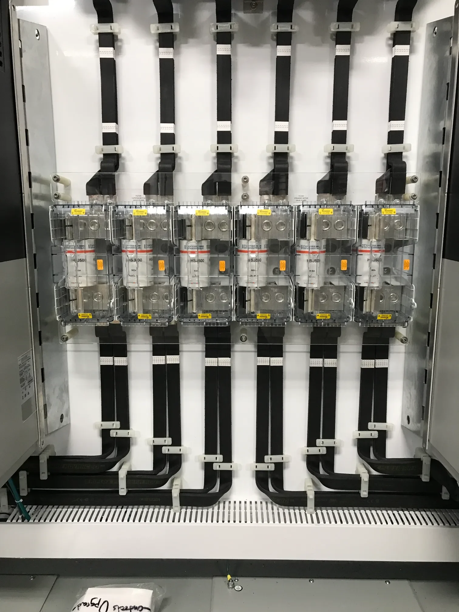 Electrical control panel with black cables connected to circuit breakers.