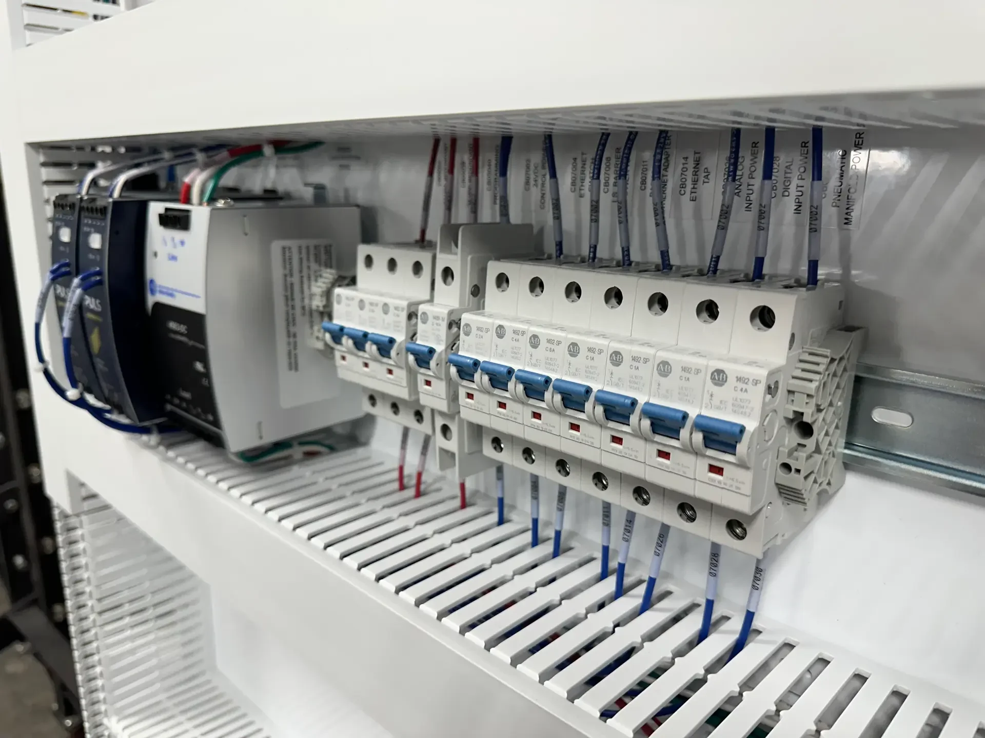 Electrical control panel with circuit breakers, wiring, and components inside.