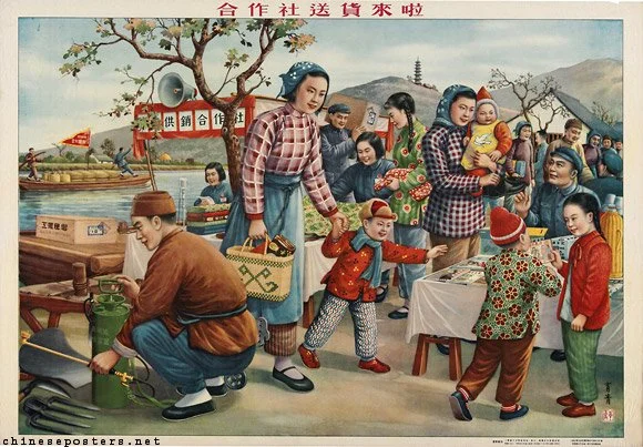 A traditional Chinese village scene with people gathering around a market stall by a river, under a tree, with mountains and a pagoda in the background. Children and adults are interacting, with some exchanging goods and others observing.