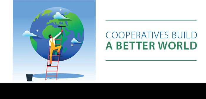 Person on ladder painting a green tree on a globe with the text 'Cooperatives Build a Better World'.