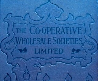 Embroidered fabric plaque with the text 'The Co-operative Wholesale Societies Limited' and decorative border design.