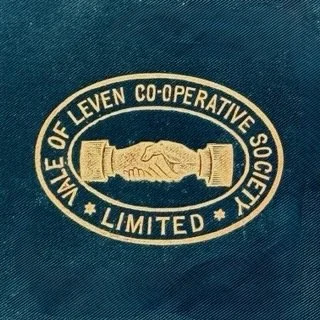 Close-up of a fabric with a circular logo of the 'Vale of Leven Co-operative Society Limited,' featuring two shaking hands in the center.
