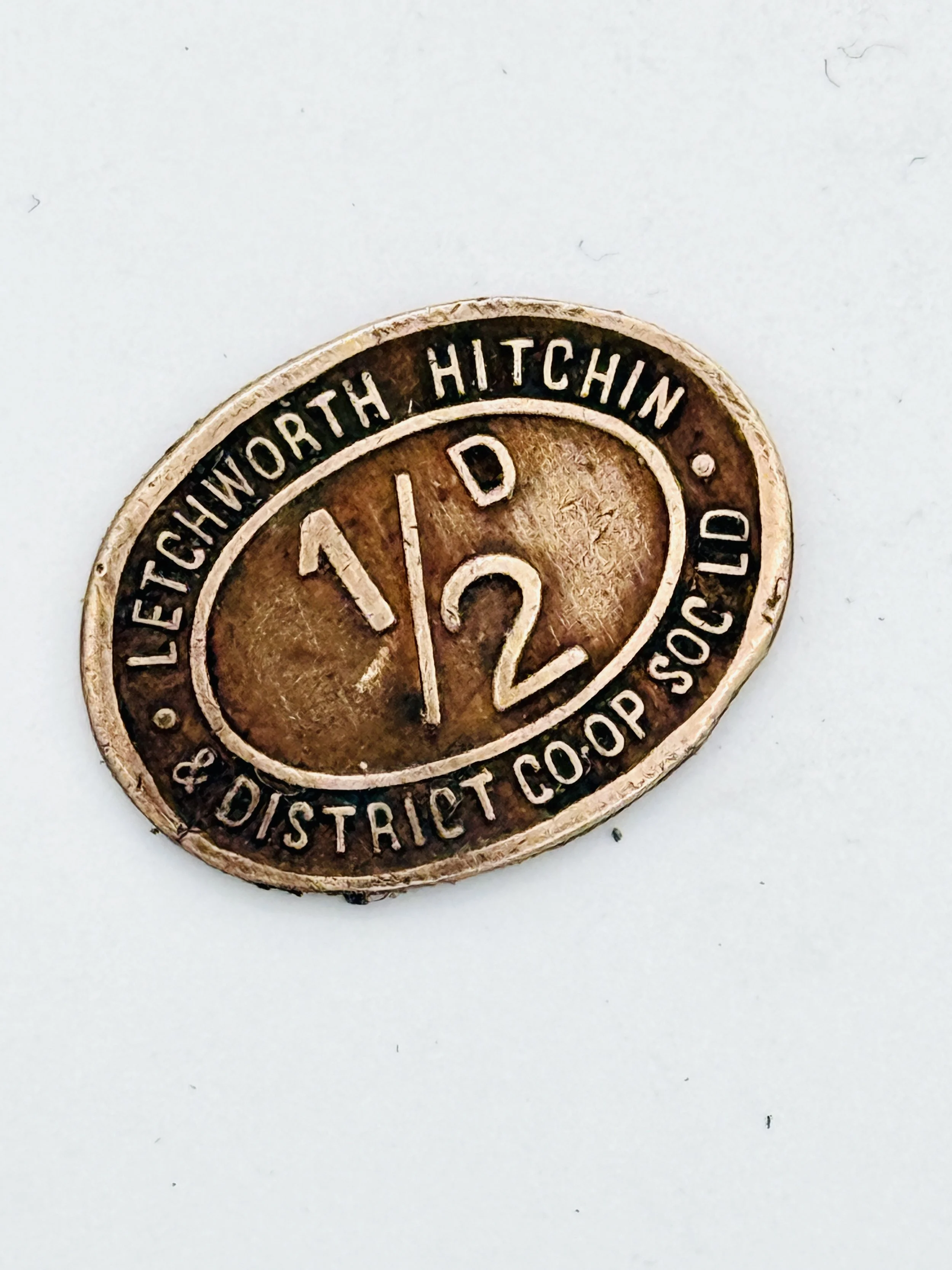 Vintage district coin from Lechworth Hitchin with the number 1/2 in the center.