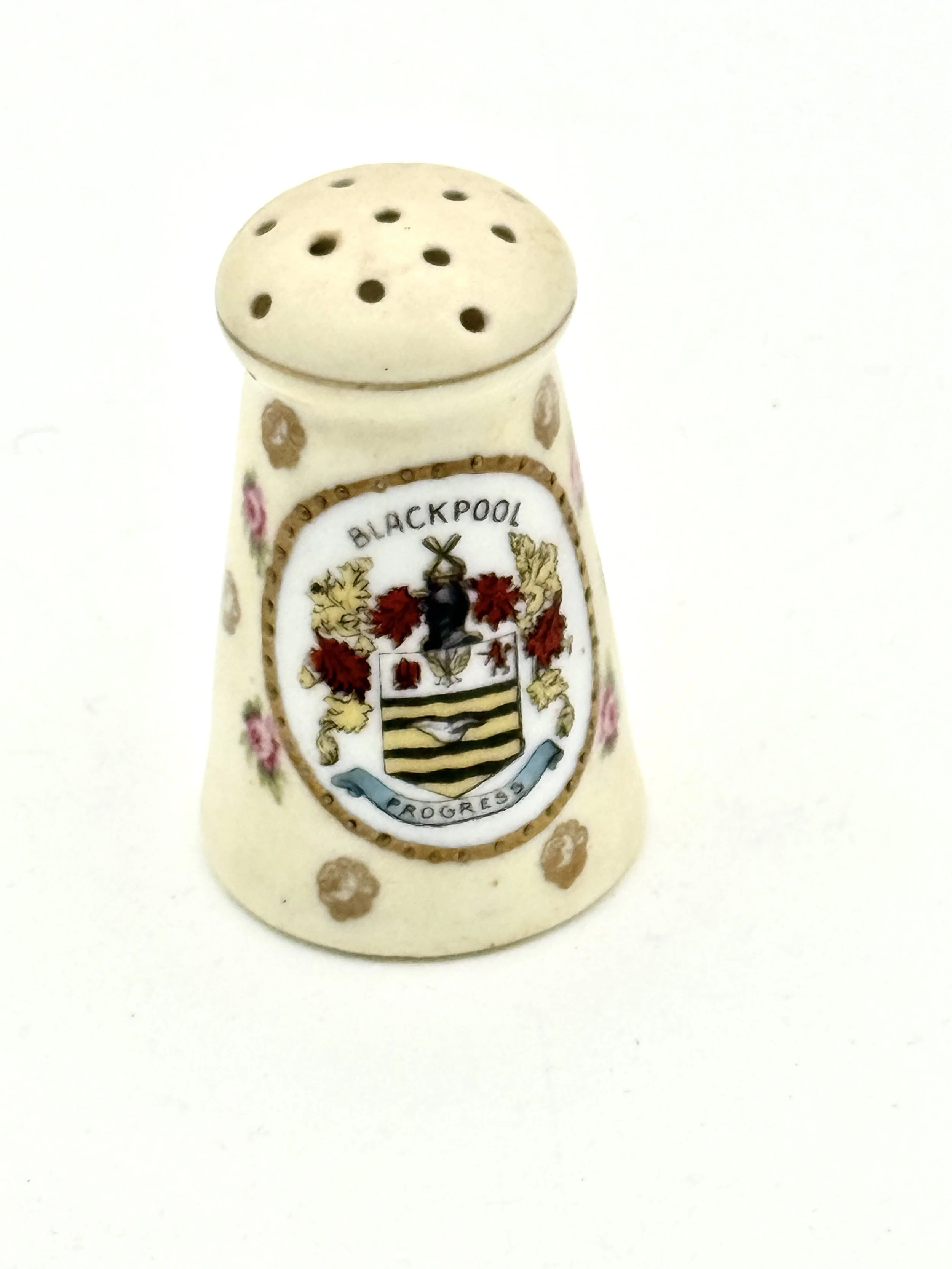 Ceramic salt shaker with the Blackpool coat of arms and floral decorations on a white background.