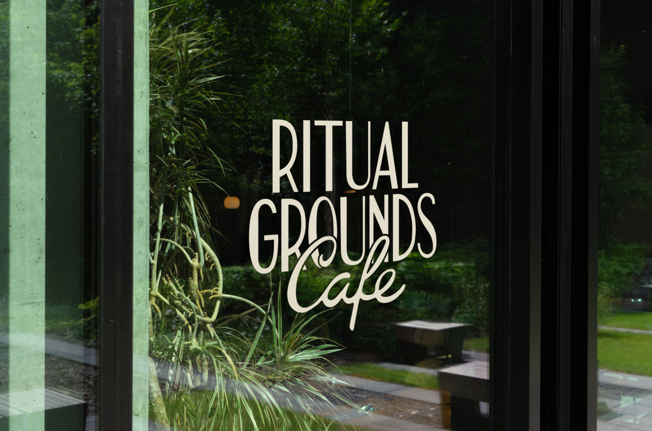 Glass window with the text 'Ritual Grounds Cafe' written on it.