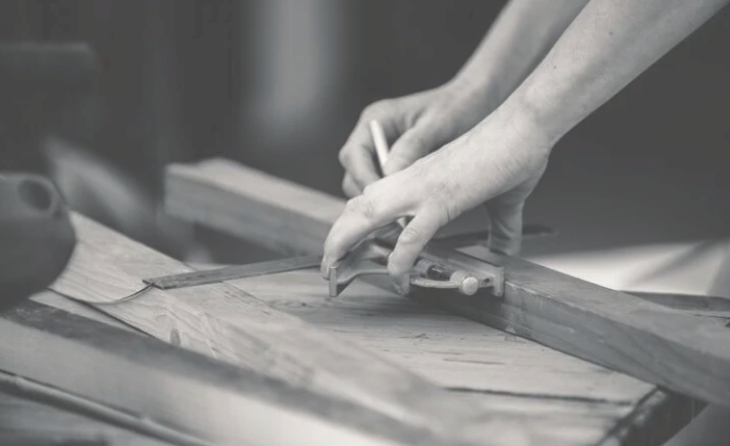 Woodworkers hands  marking out wood with a combination square