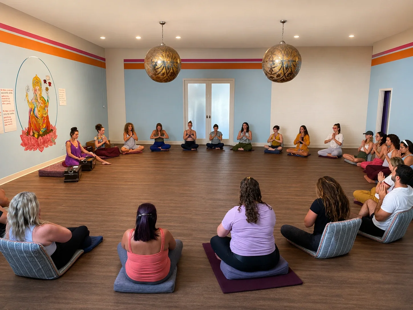 Group of students at Sukha Yoga Austin sitting in a circle practicing mantra meditation during a Bhakti Training.
