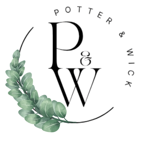 A transparent glass of white wine on a table decorated with green leaves.