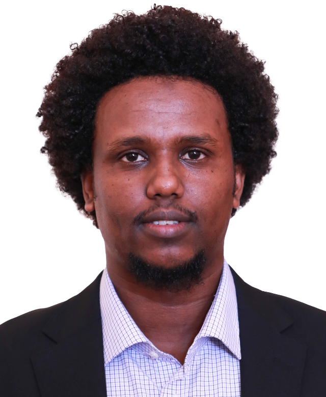 Headshot of a man with curly hair wearing a suit and collared shirt on a plain white background.