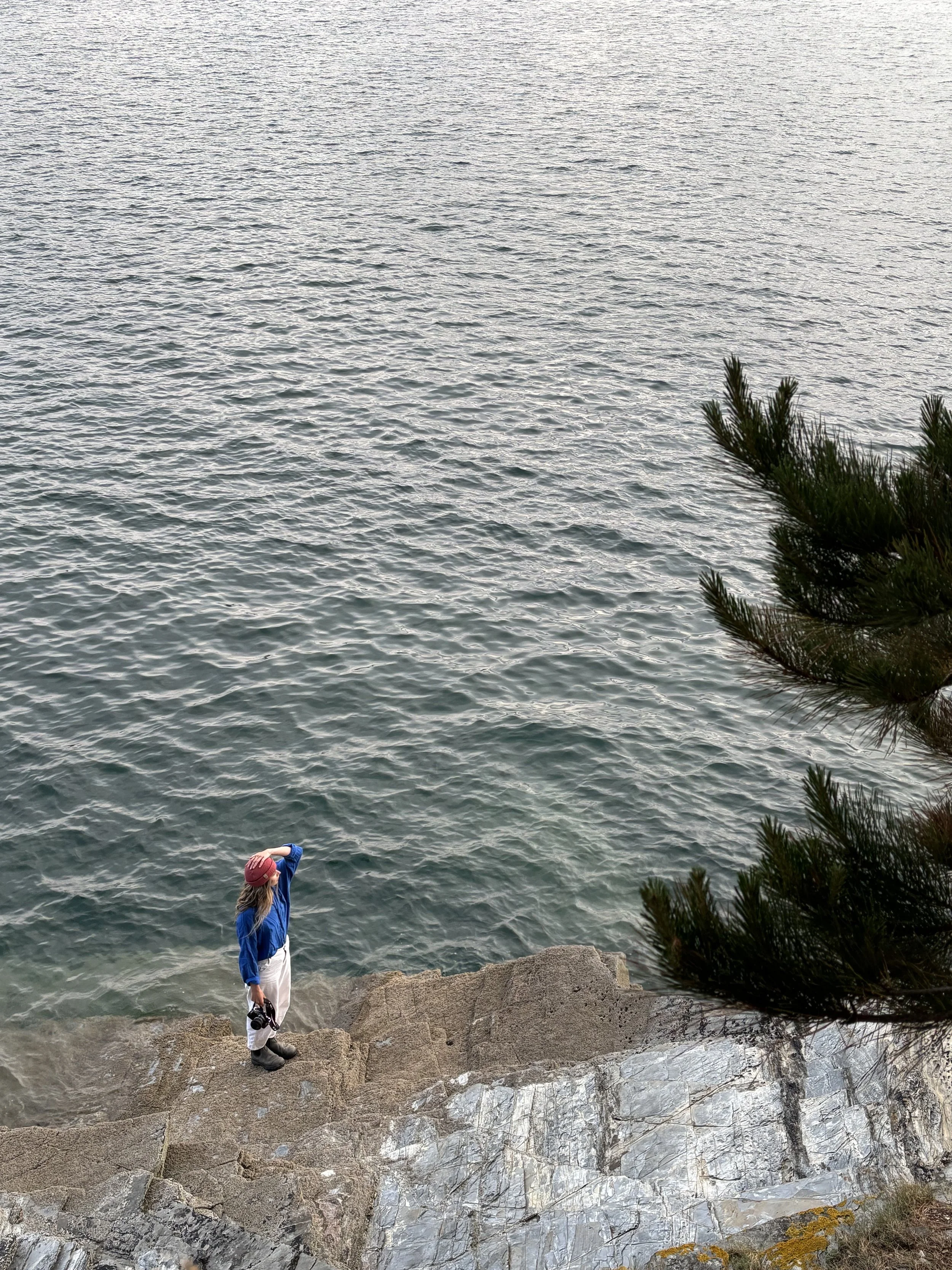 Woman standing on a rock by the sea