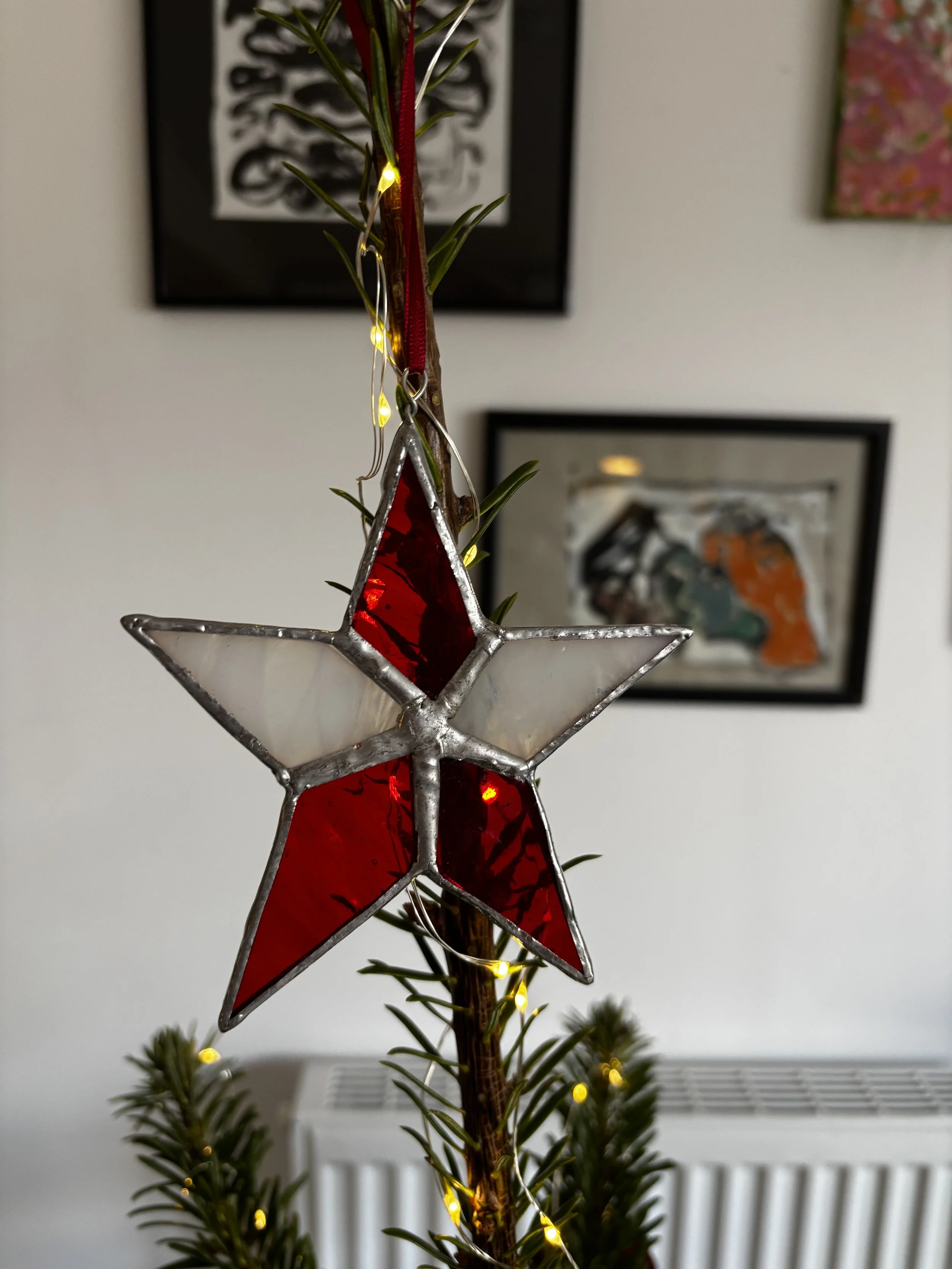 Red and white stained glass star on Christmas tree