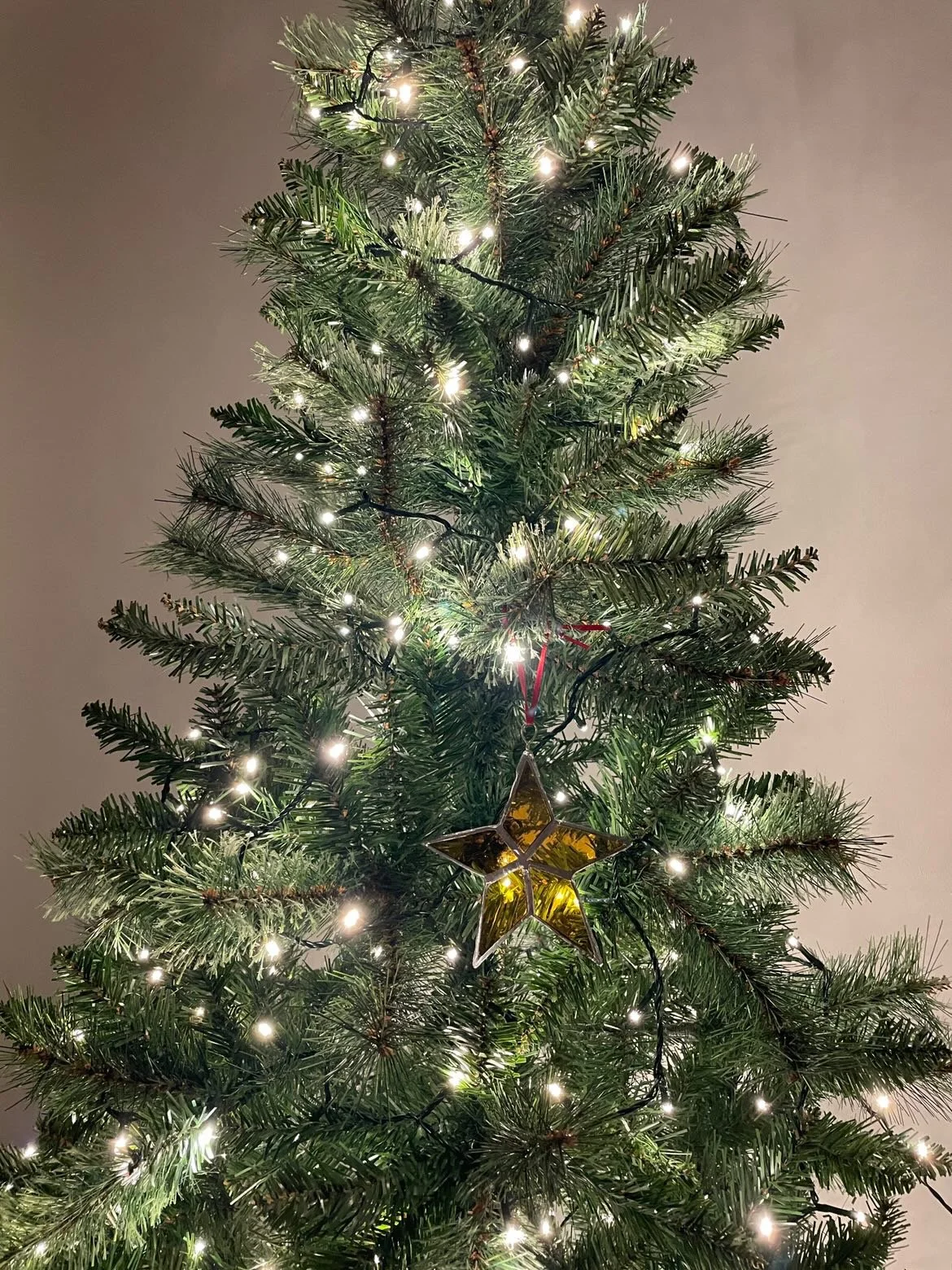 yellow stained glass star on a Christmas tree