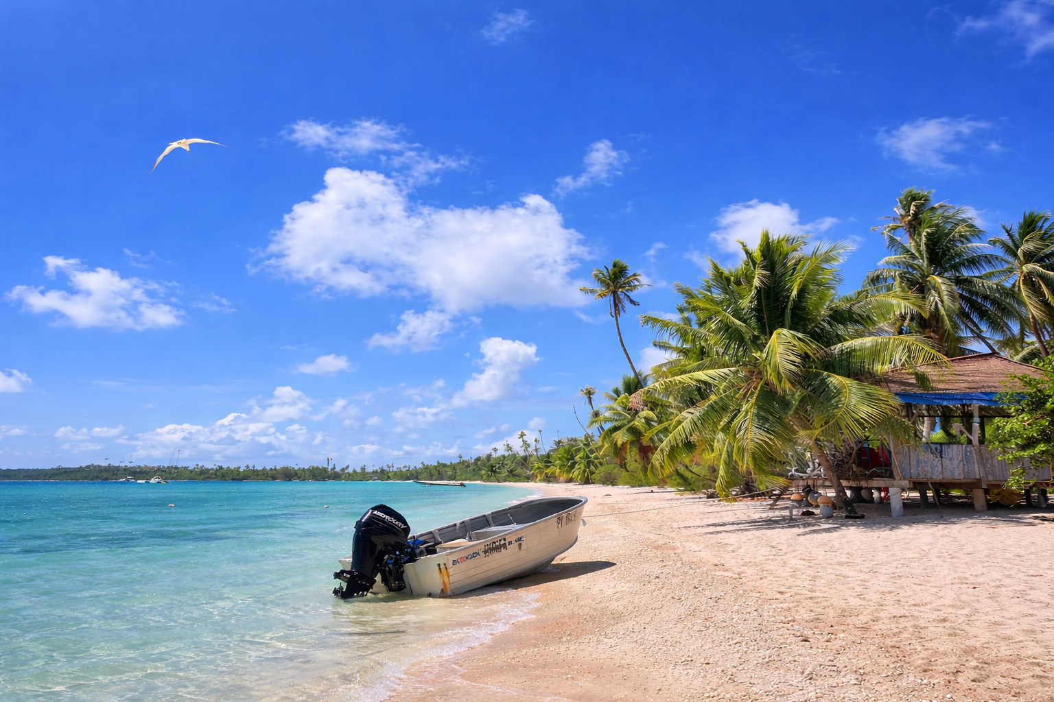 Plage de Fakarava avec bateau au bord du lagon turquoise