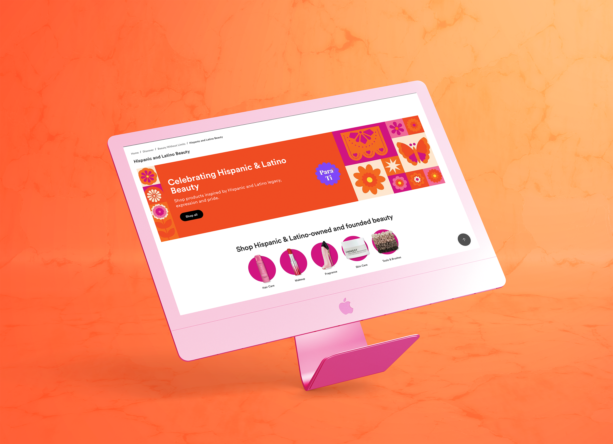Pink iMac computer displaying a website titled "Celebrating Hispanic & Latino Beauty" with colorful geometric and floral patterns, set against a textured orange background.
