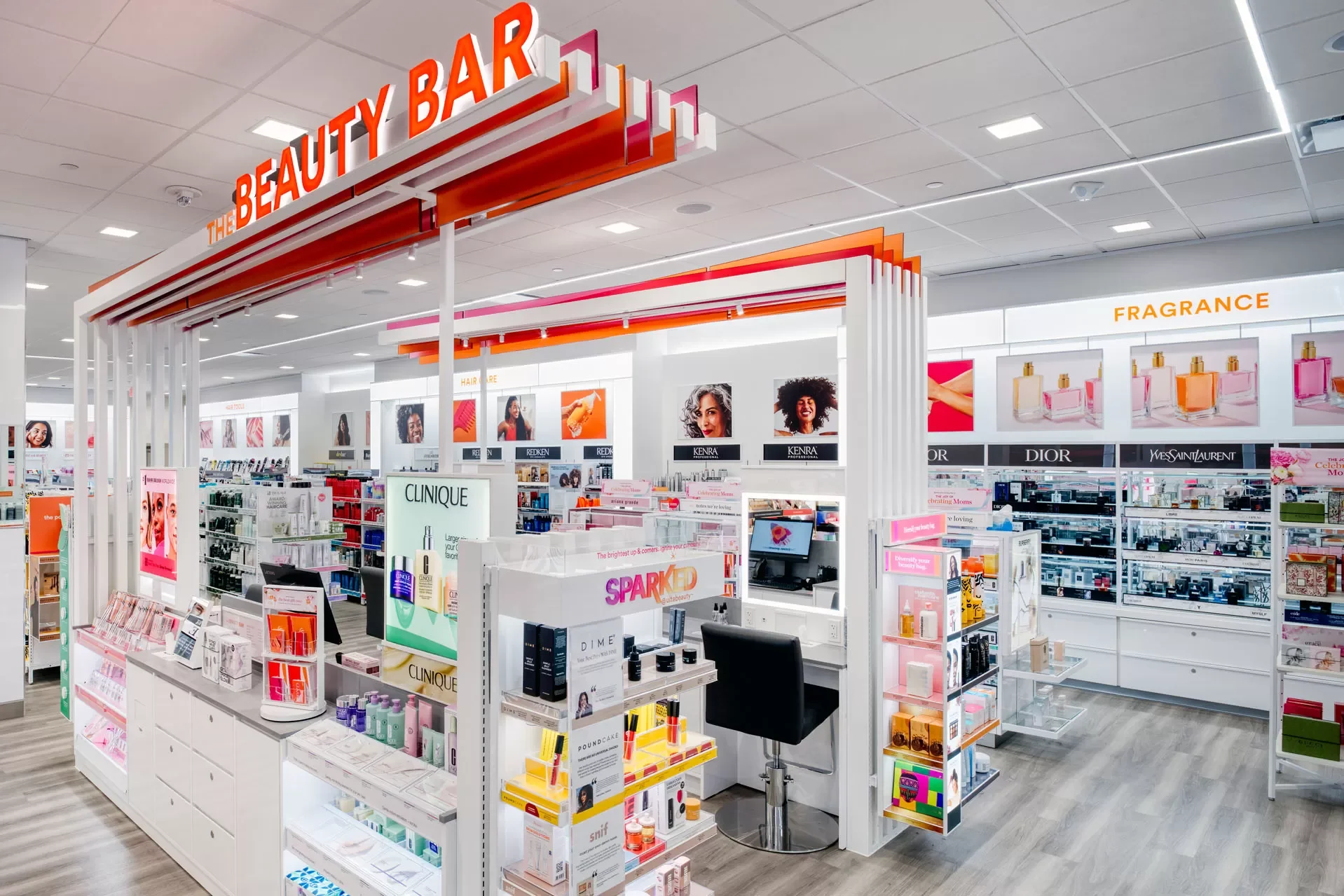 Interior of a beauty store with shelves of skincare, haircare, and fragrance products, and a sign reading 'The Beauty Bar' at the entrance.