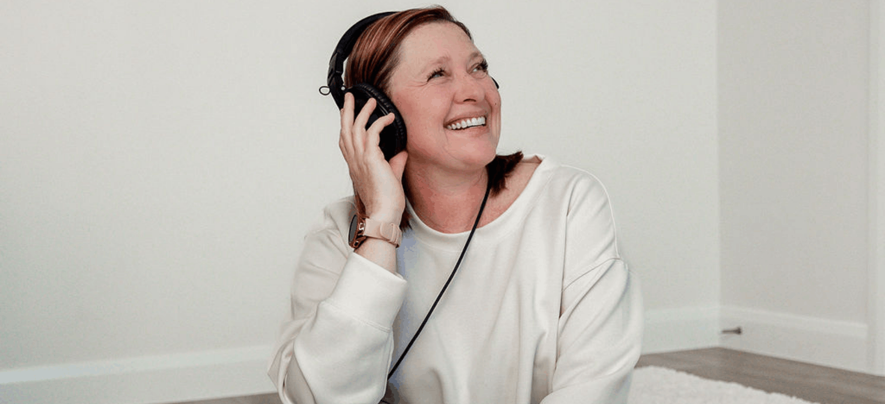 Liz Chapman looking upwards with headphones on and smiling