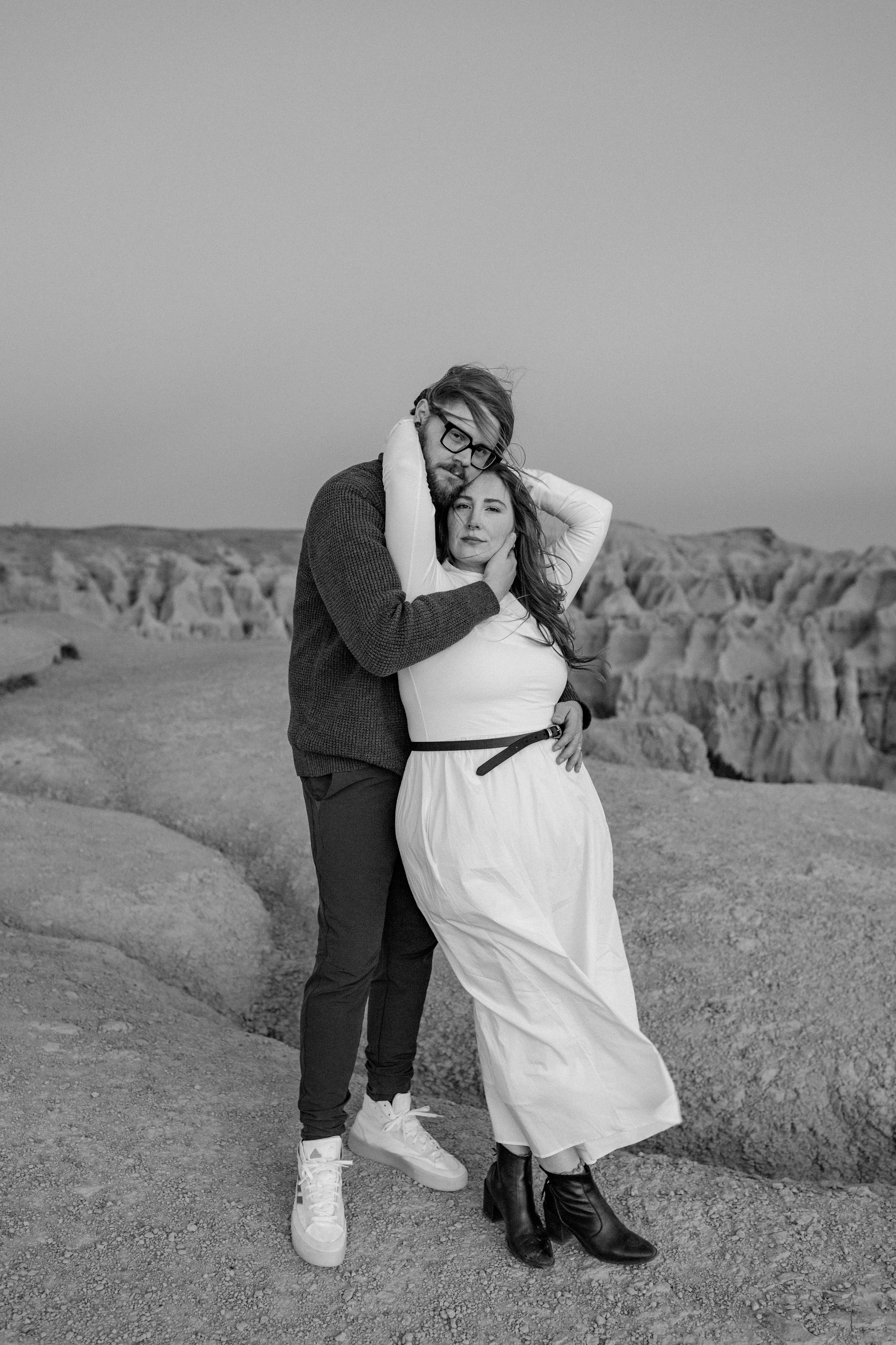 Bride and groom walking in the Badlands during golden hour captured by South Dakota wedding photographer Bri Cowan