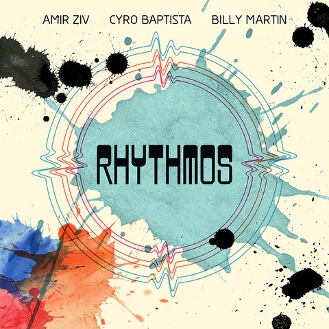Album cover titled 'Rhythmos' by Amir Ziv, Cyro Baptista, and Billy Martin, featuring a splash of watercolor backgrounds with black ink splatters and concentric circle designs.