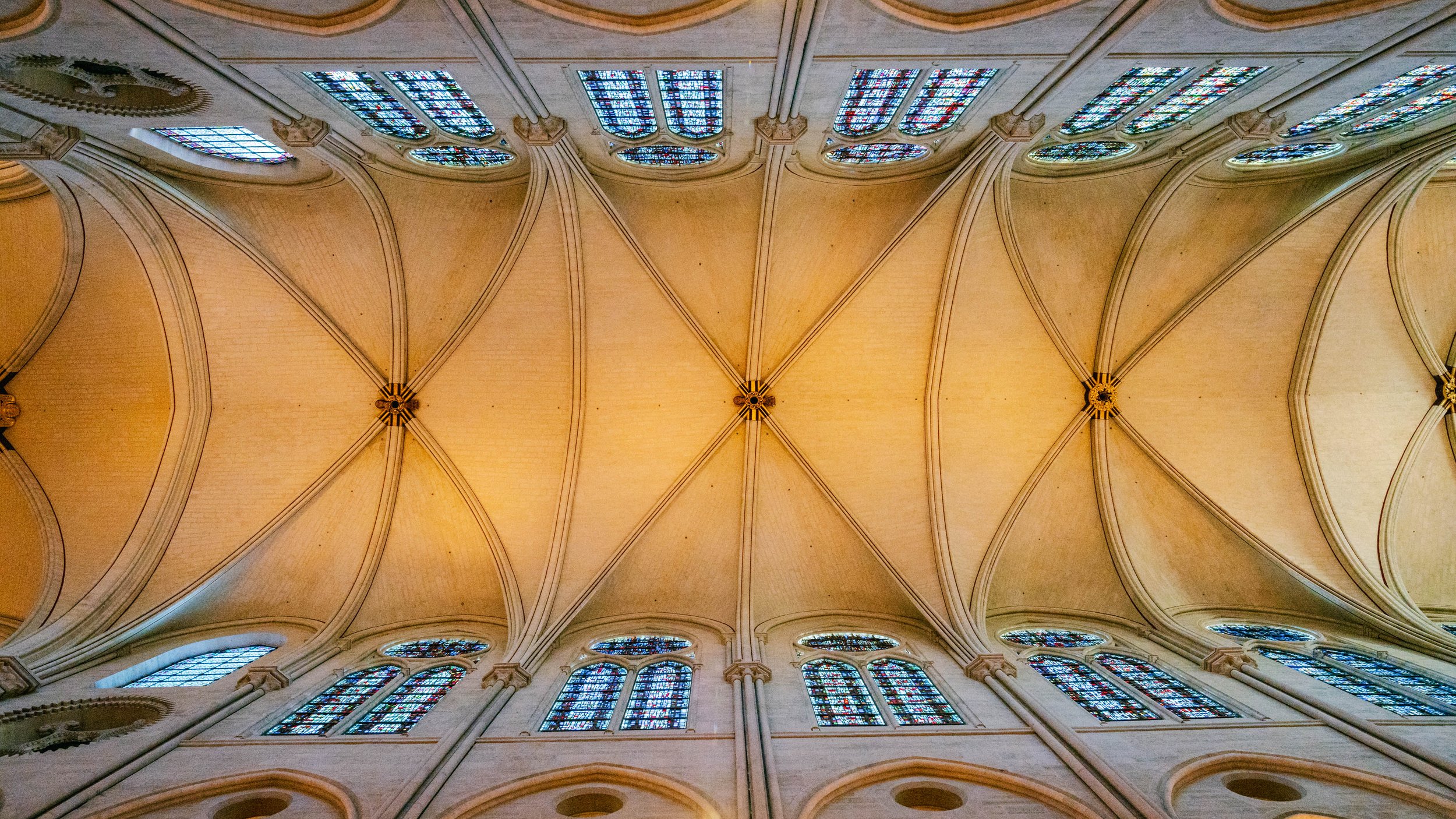 Interior of a church with a vaulted ceiling and stained glass windows.