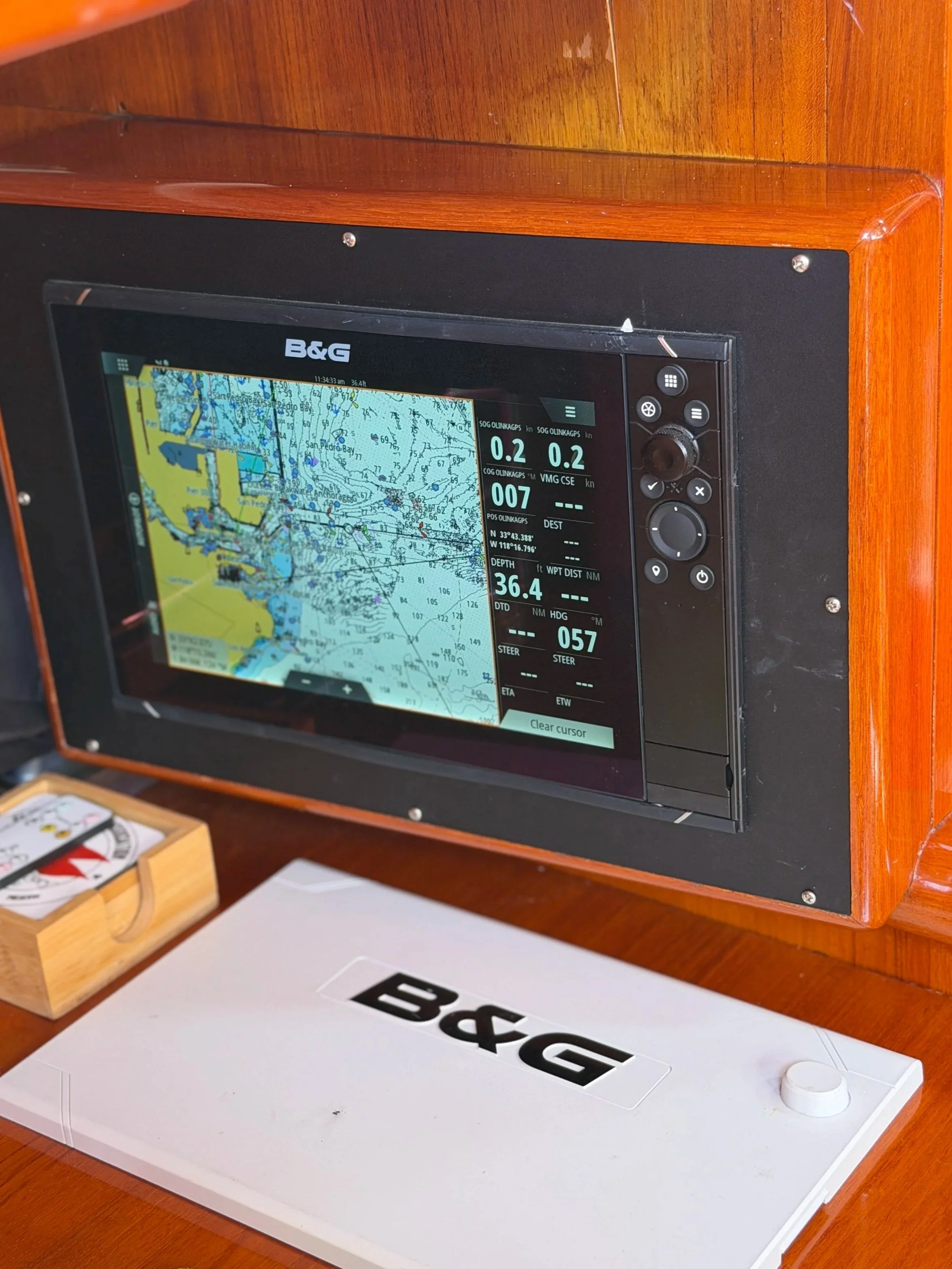 Navigation display screen showing a nautical chart with water depths, navigation routes, and charted landmarks, on a boat's navigation panel.
