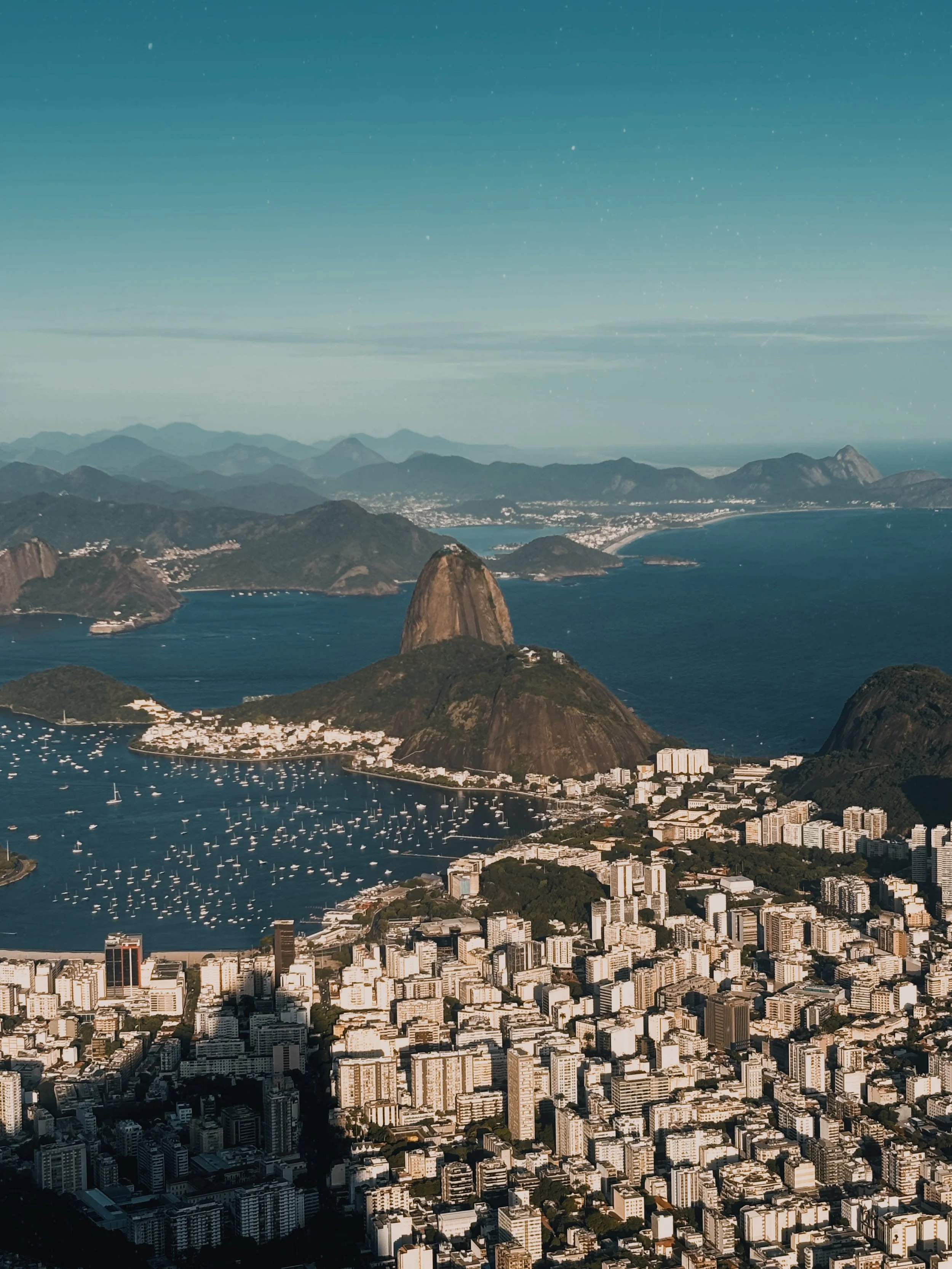 Aerial view of Rio de Janeiro featuring Sugarloaf Mountain, the city skyline, and Guanabara Bay on a clear day.