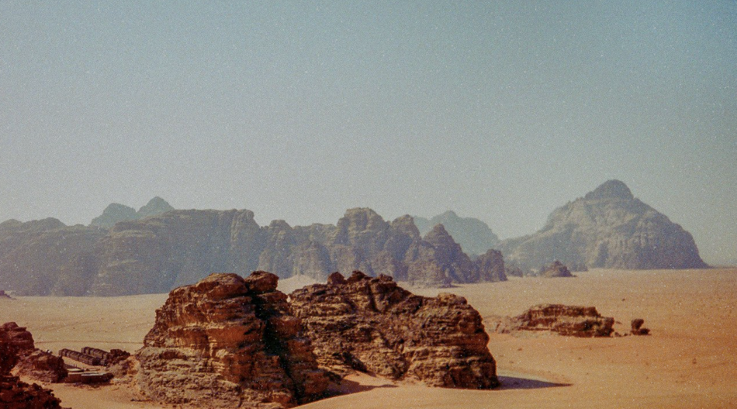 Desert landscape with large rock formations under a clear sky.