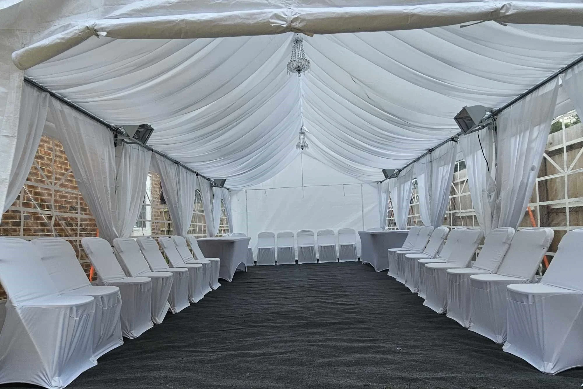 Classic white marquee interior with full draping and banquet seating for formal event