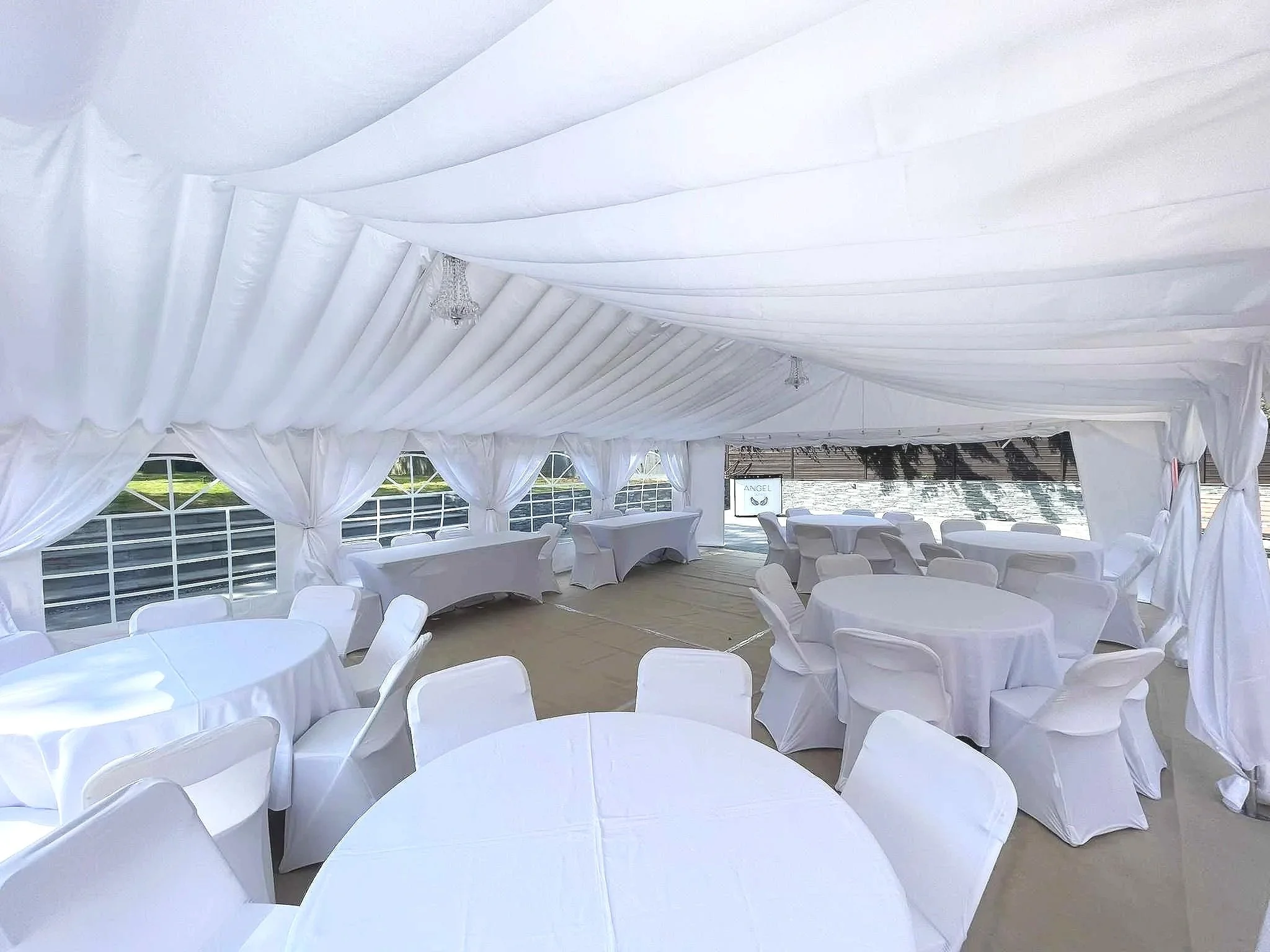 Corporate event marquee interior with tables and draped ceiling – NK Marquees