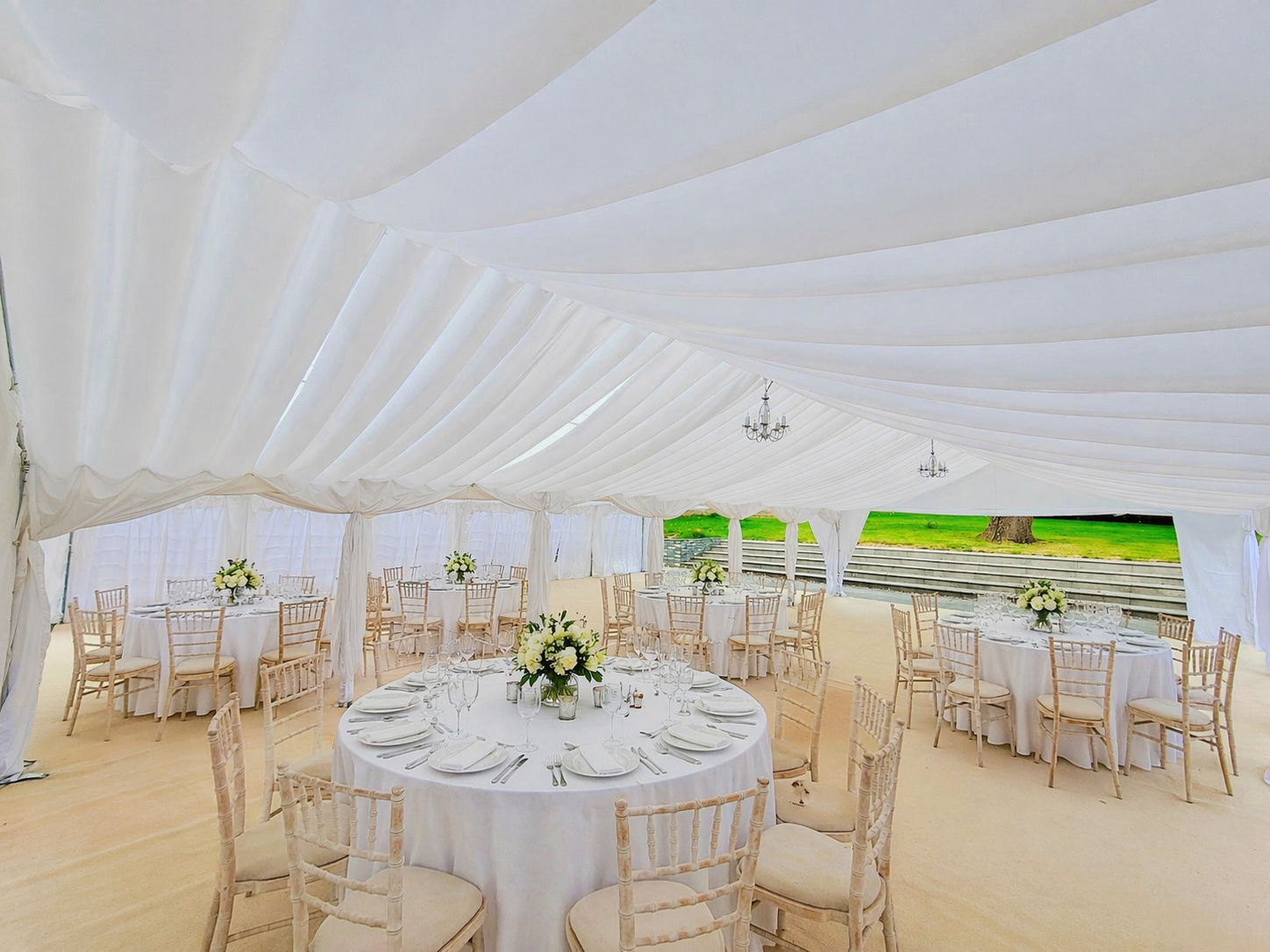 large marquee with round tables and elegant lining