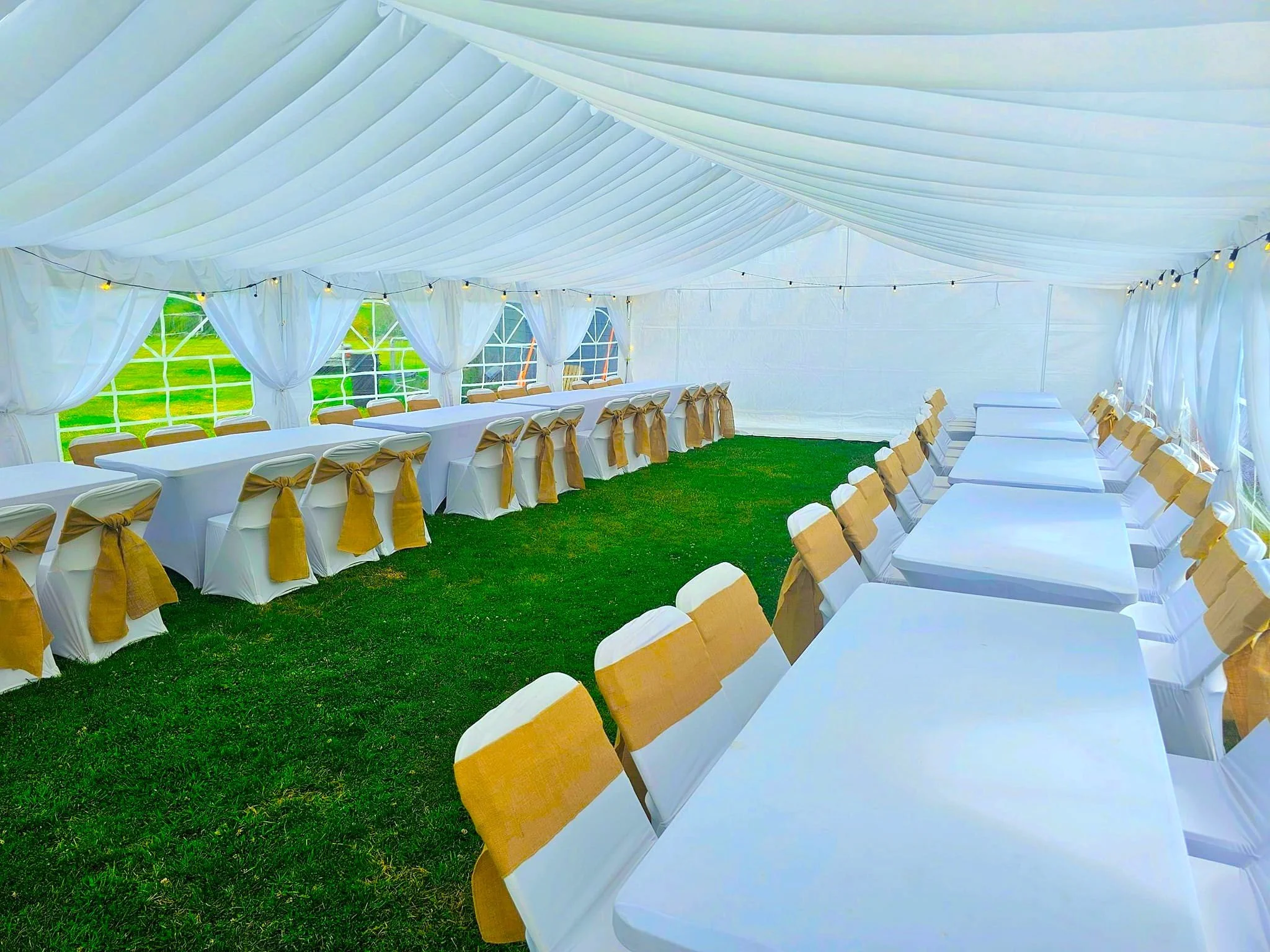 Long banquet dining layout inside luxury marquee by NK Marquees – wedding marquee hire Leicester and Northampton