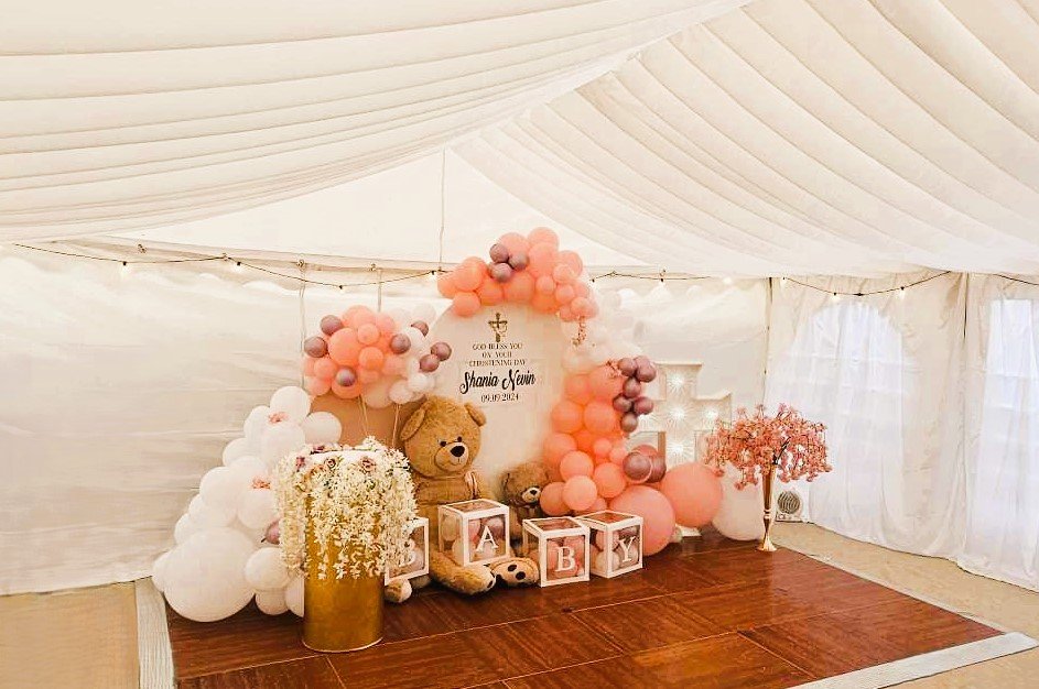 Decorated marquee interior with balloons, backdrop and seating for baby shower event